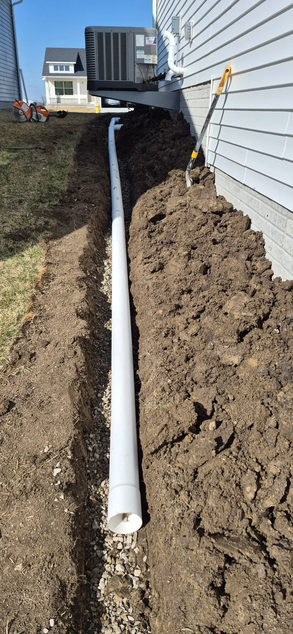 Professional French drain and PVC pipe installation, a crucial step for proper site drainage and concrete longevity.