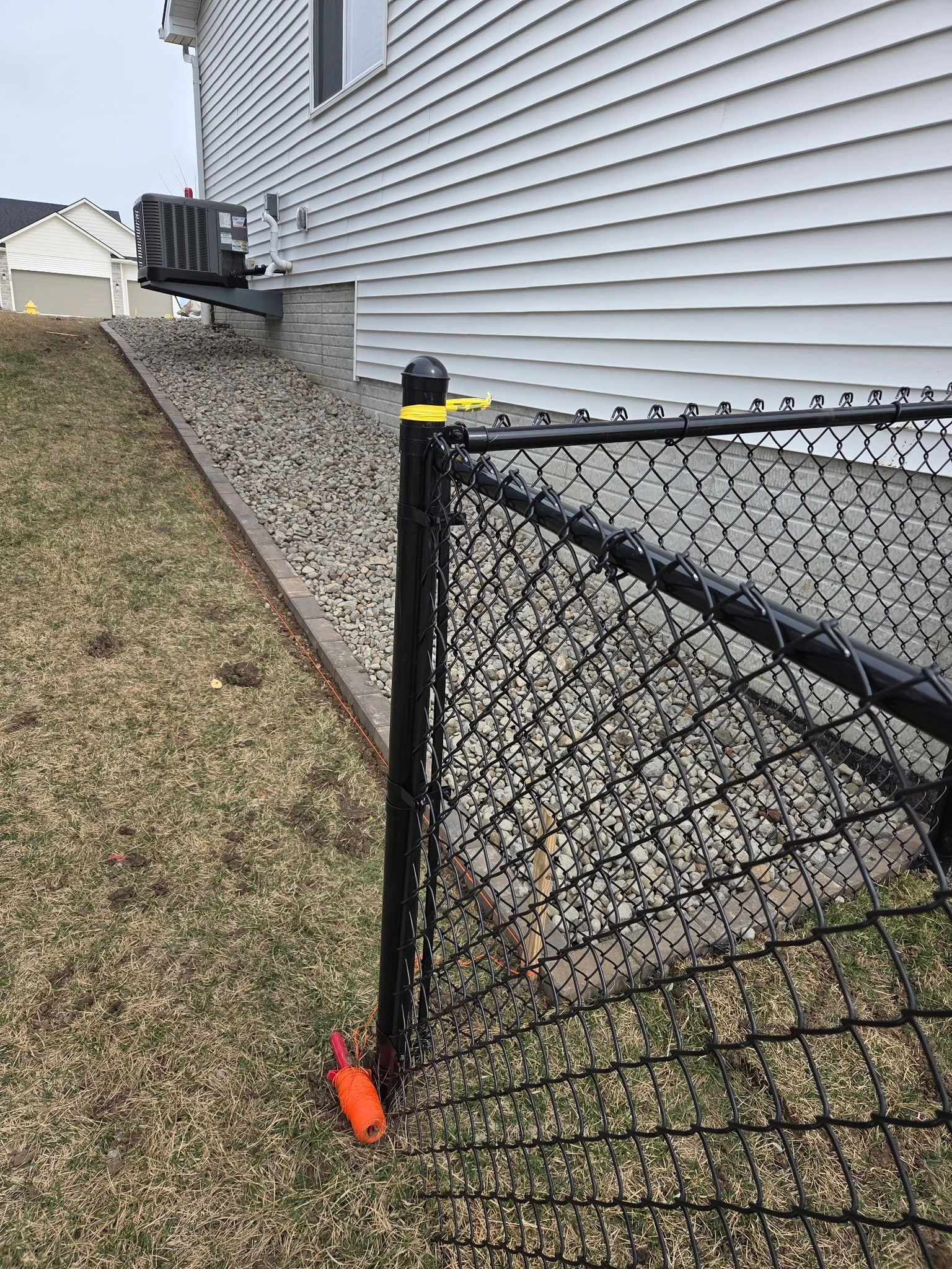 Clean, low-maintenance decorative rock border and edging installed along a residential foundation.