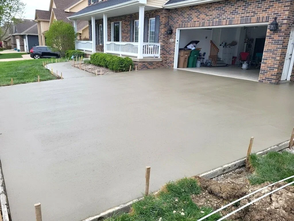 A pristine, completed residential concrete driveway, ready to use, featuring clean control joints in Ankeny.