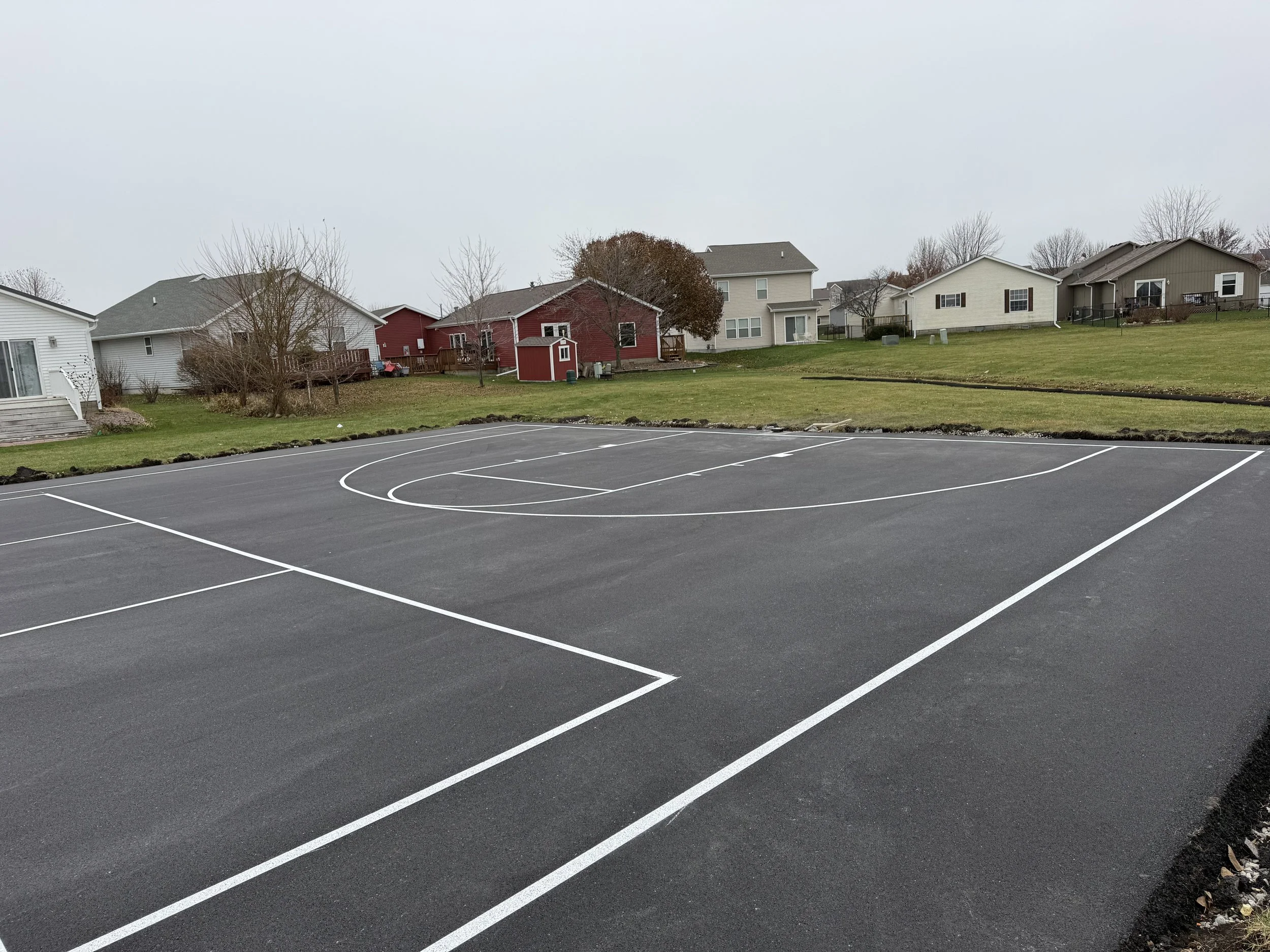 Custom residential basketball court installation and professional line striping for the ultimate backyard setup.
