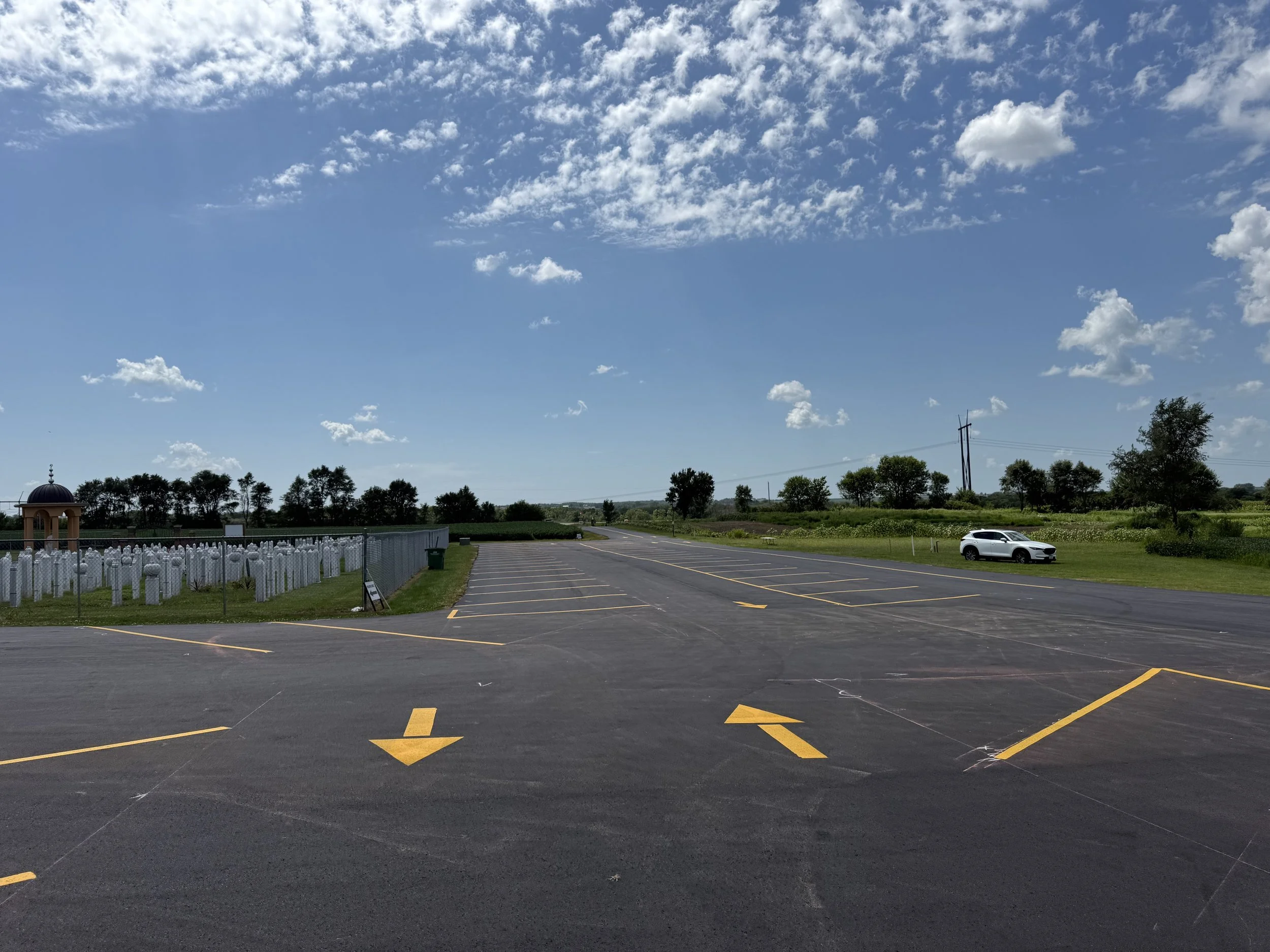 Large commercial parking lot installation with professional, high-visibility line striping and traffic flow arrows.