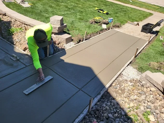 Dedicated craftsmanship carefully troweling the edge for a perfect finish on a new concrete sidewalk.