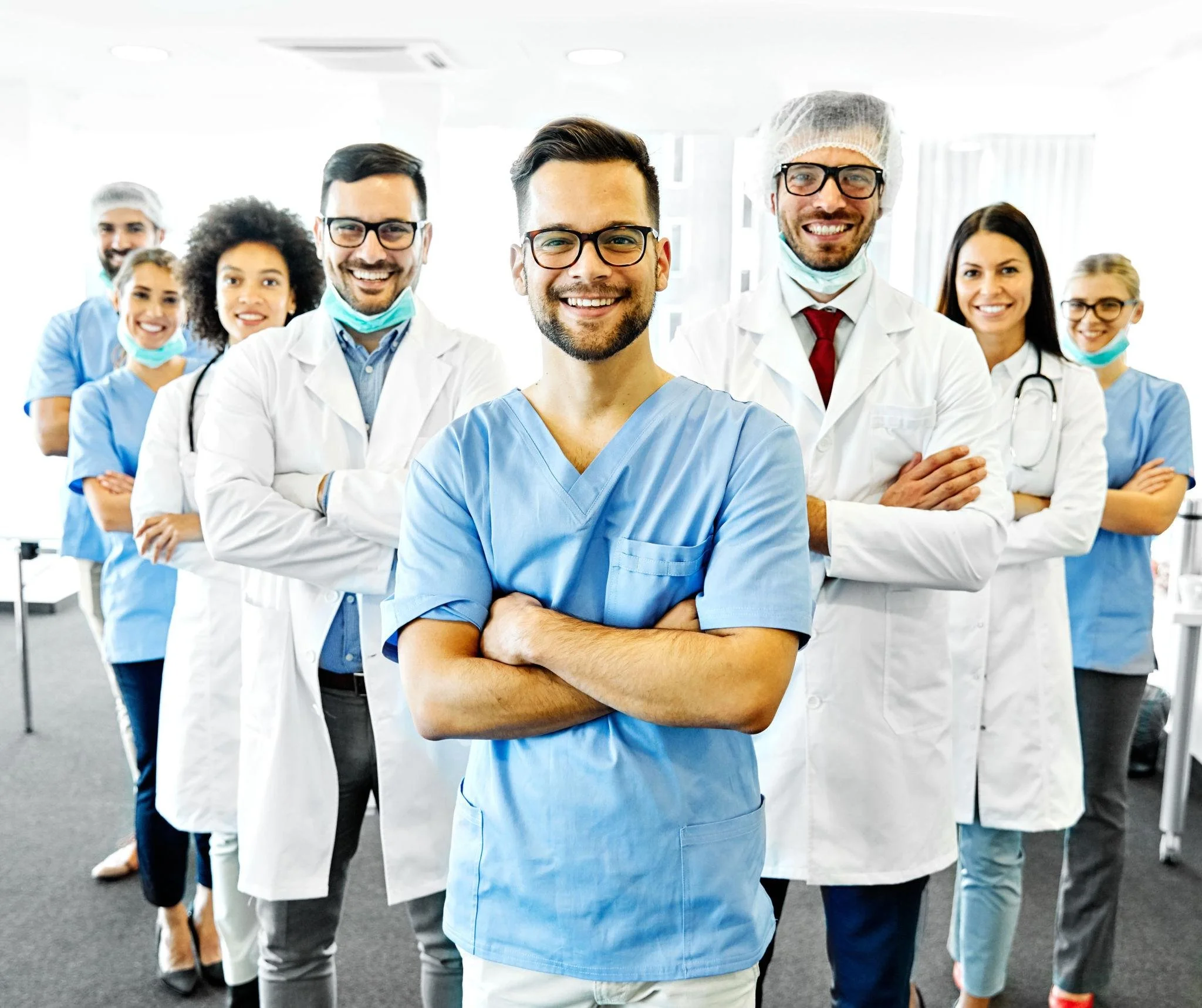 Group of diverse medical professionals including doctors and nurses, standing confidently in a hospital setting.