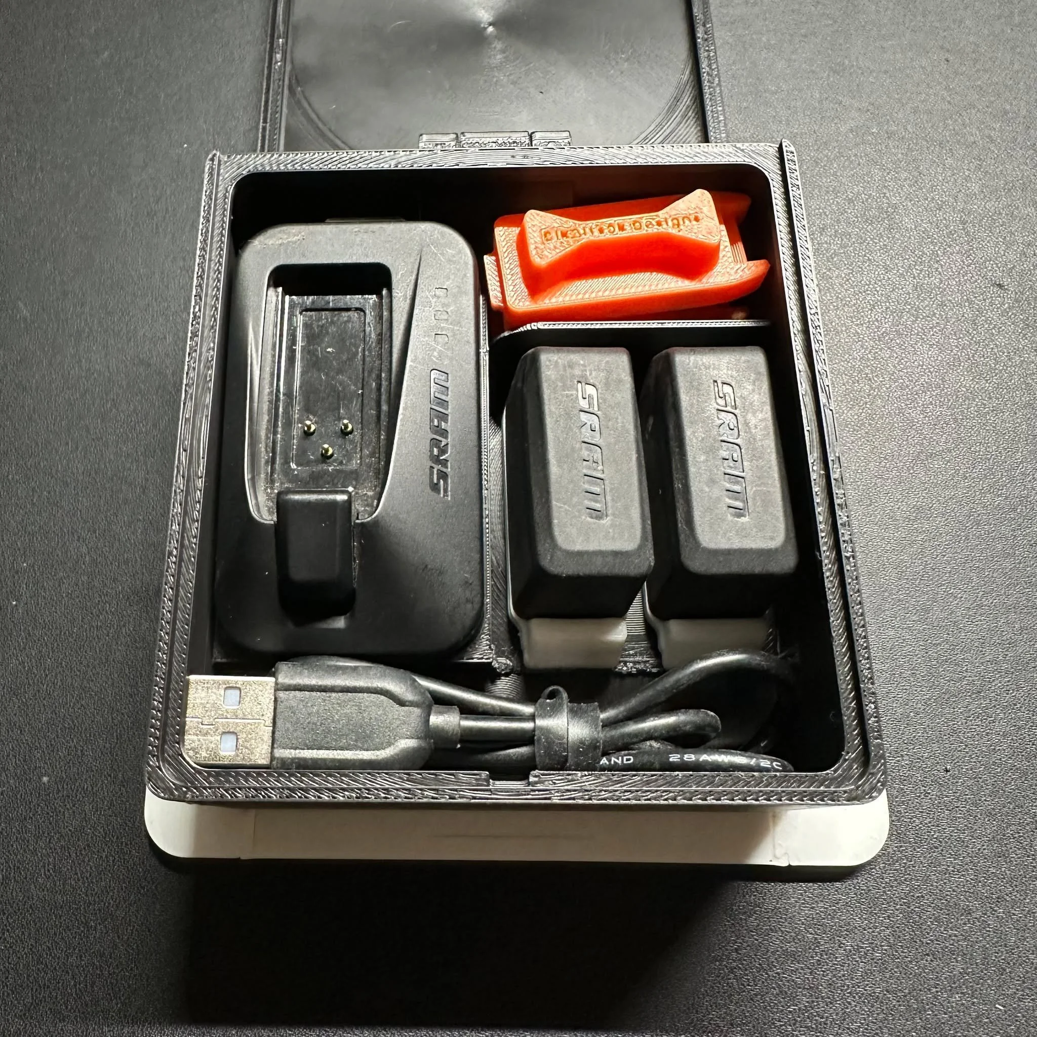 🔧📦 Todo tu ecosistema electr&oacute;nico, en un solo lugar
Dise&ntilde;ada para ciclistas que cuidan cada detalle.�Esta caja te permite almacenar cargador, bater&iacute;as y accesorios electr&oacute;nicos, incluyendo el cable para transmisiones SRA