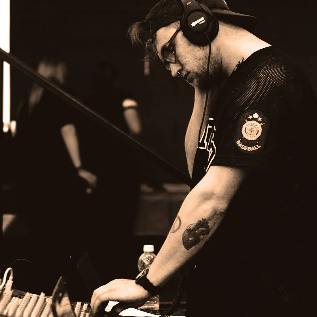 DJ wearing headphones adjusting mixer