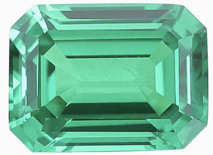 A large emerald-cut green gemstone.