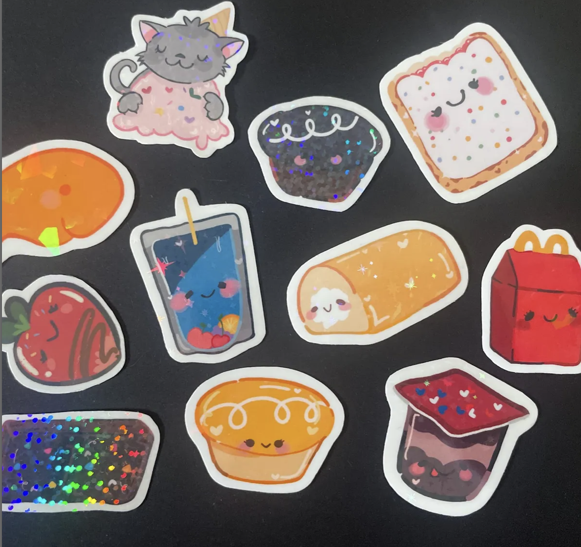 Collection of colorful kawaii-style sticker illustrations of various food items including a gray cat, a cupcake, a slice of cake, a soda, a can of juice, an orange, a red box of fries, a jelly cup, and a sushi roll, all with happy facial expressions on a black background.