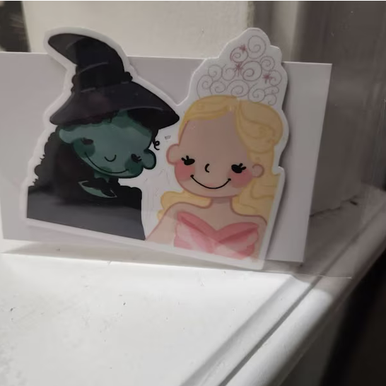 Cartoon illustration of Wicked Witch of the West and Glinda the Good Witch from The Wizard of Oz, with smiling faces and detailed backgrounds.