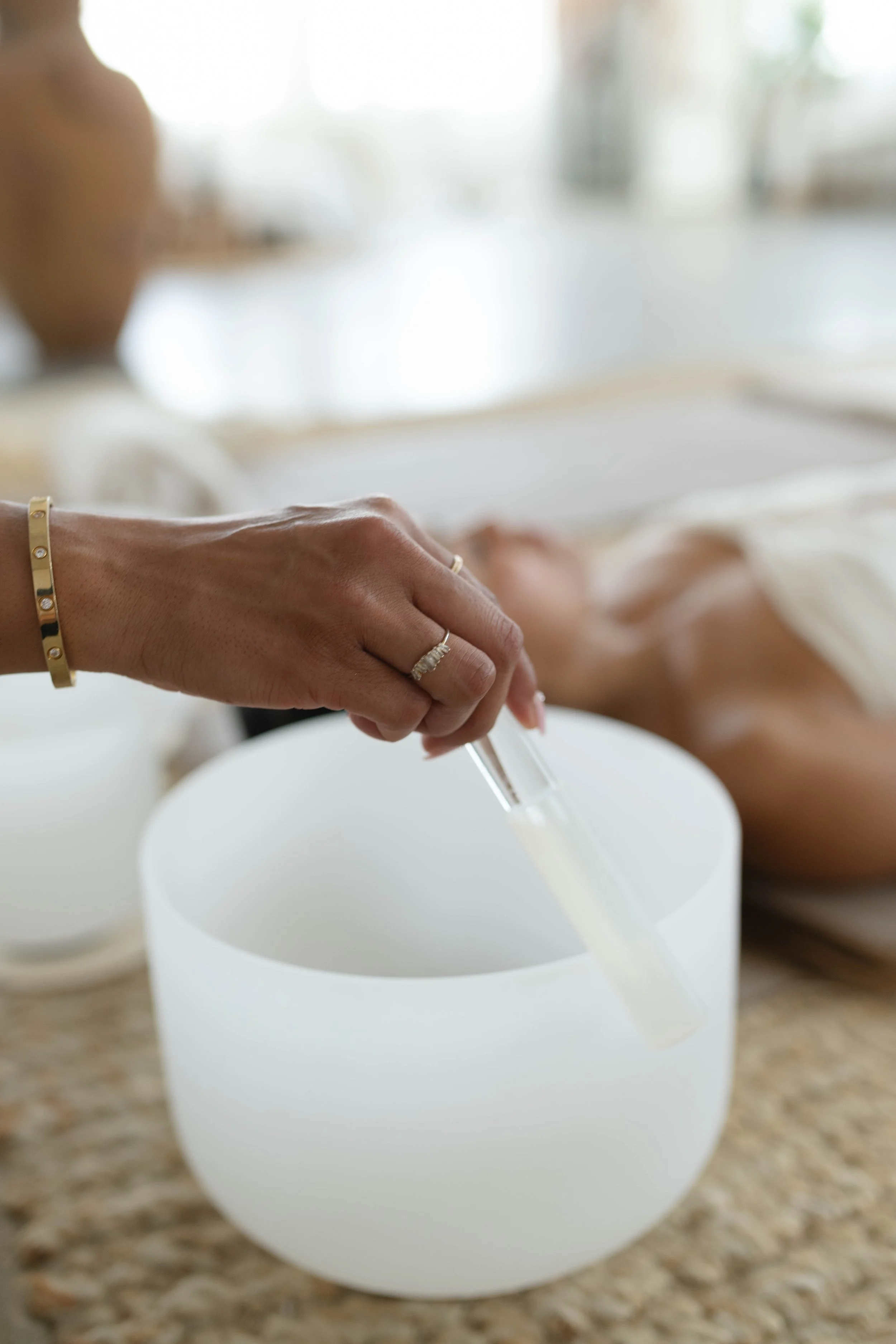 Close-up of a trauma-informed sound healing session using frosted crystal singing bowls by Dee Franklin of AMRA LIGHT in Los Angeles