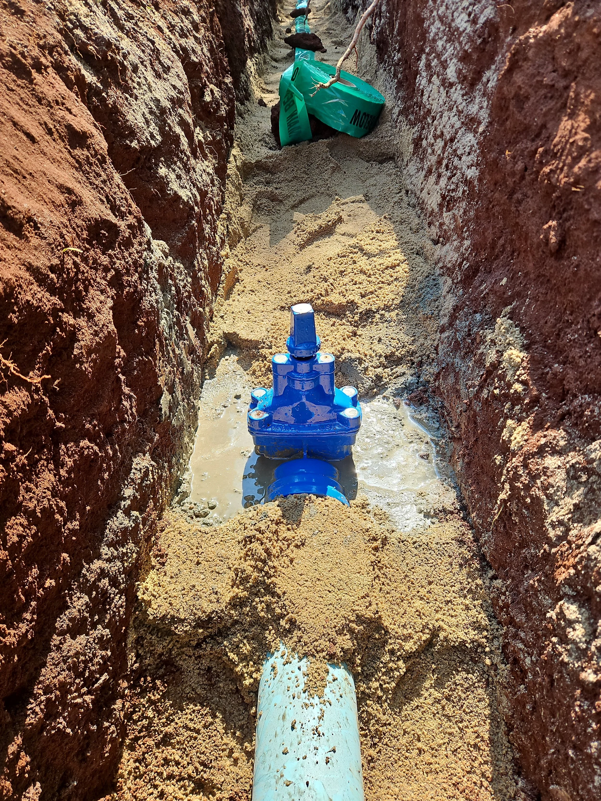 A 150mm water mains shutoff valve installed in a trench with sand around.