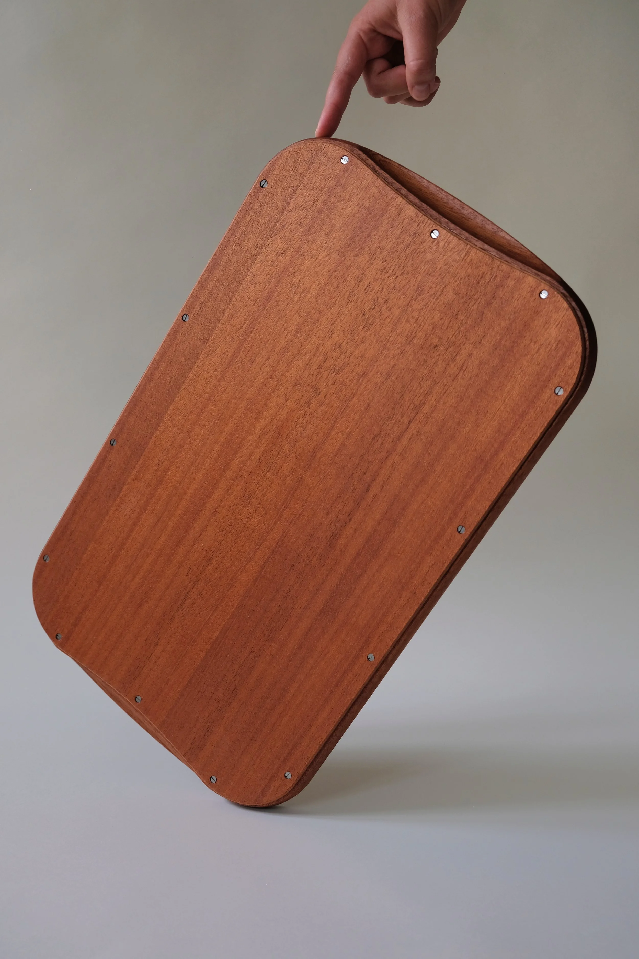 Arv serveringsbakke i mahogni, vist på højkant med flot åretegning og rundinger.