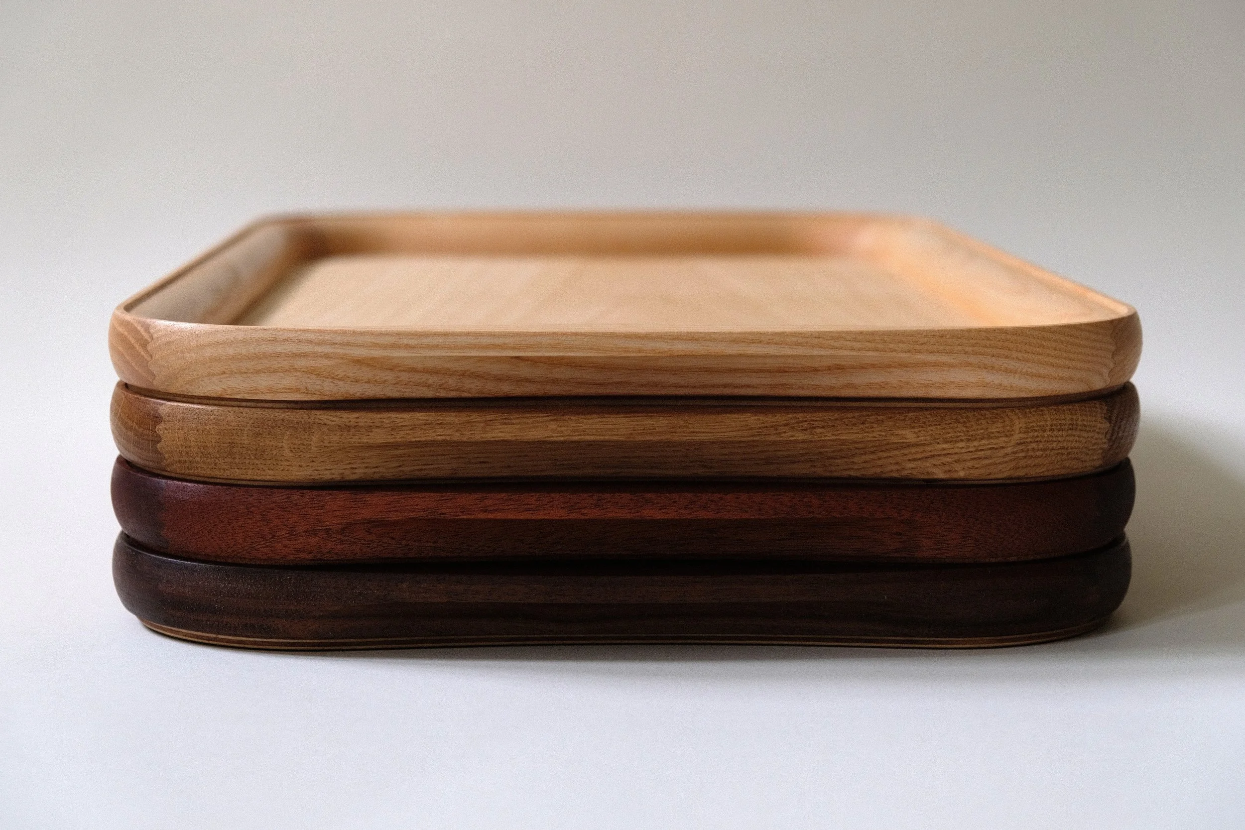 Arv serveringsbakke i flere træsorter, stablet ovenpå hinanden.