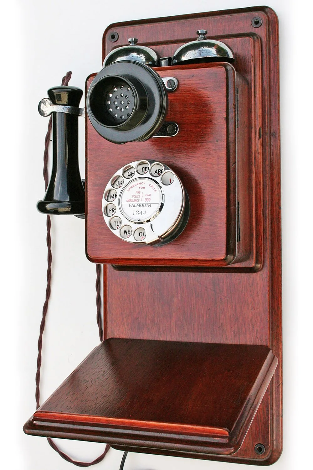 Vintage wooden wall-mounted rotary telephone with black handset and numbered dial.