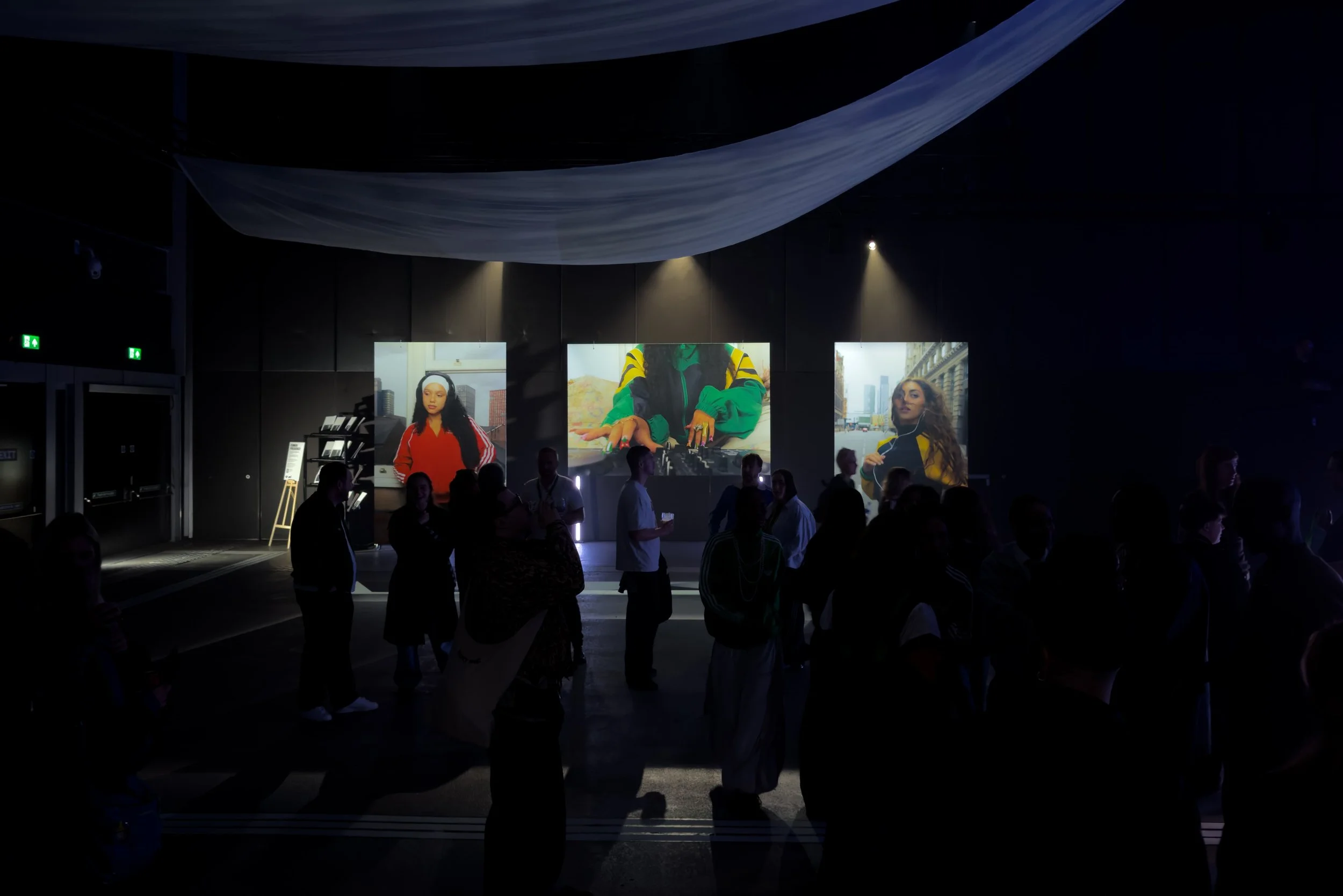 Visitors viewing large-scale colour photographs by Manchester-based photographer Yaroslav Prytula at the Common Frequency exhibition at Factory International.