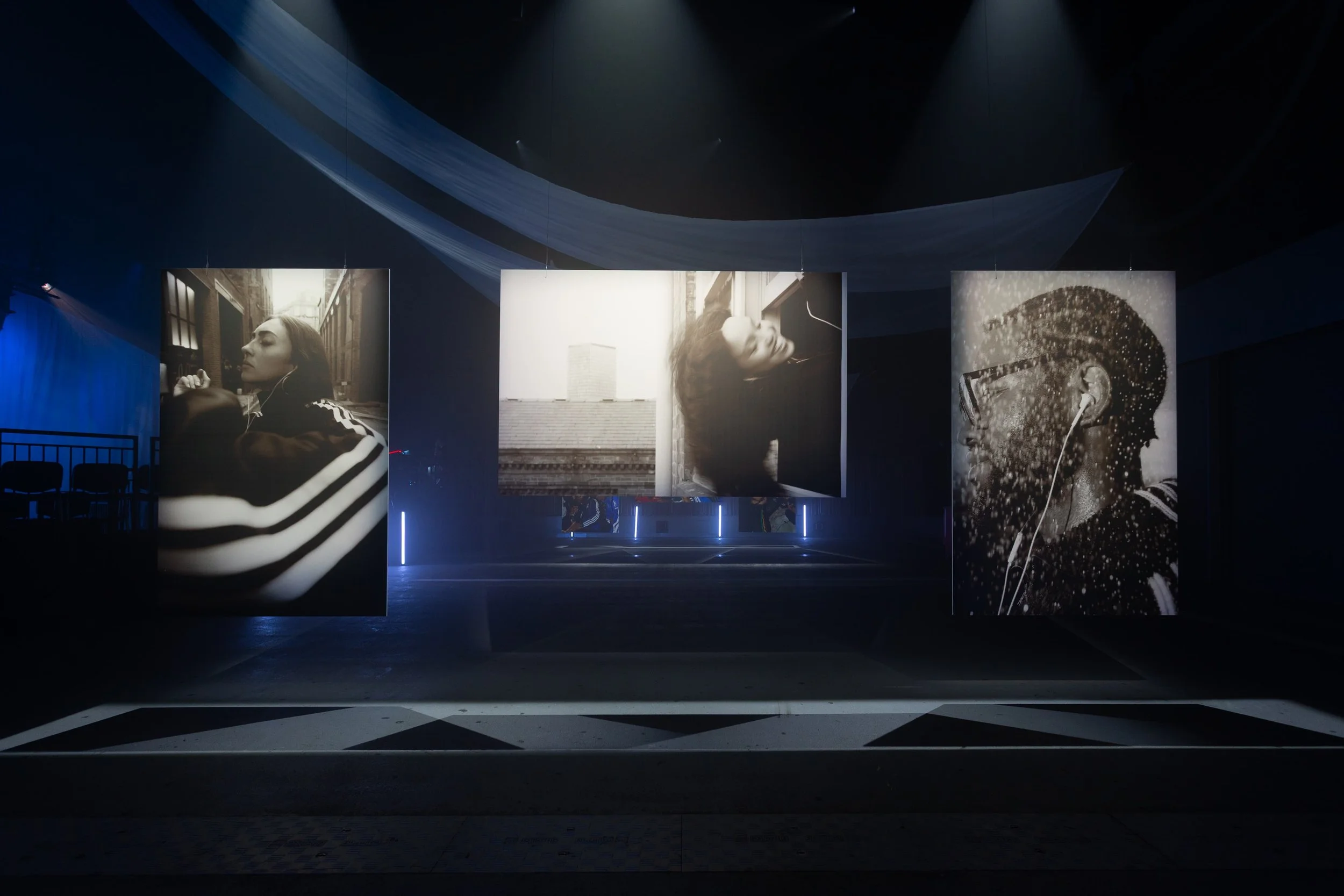 Three suspended black-and-white photographic prints from Somewhere in the Music by Yaroslav Prytula at Factory International in Manchester for Common Frequency.
