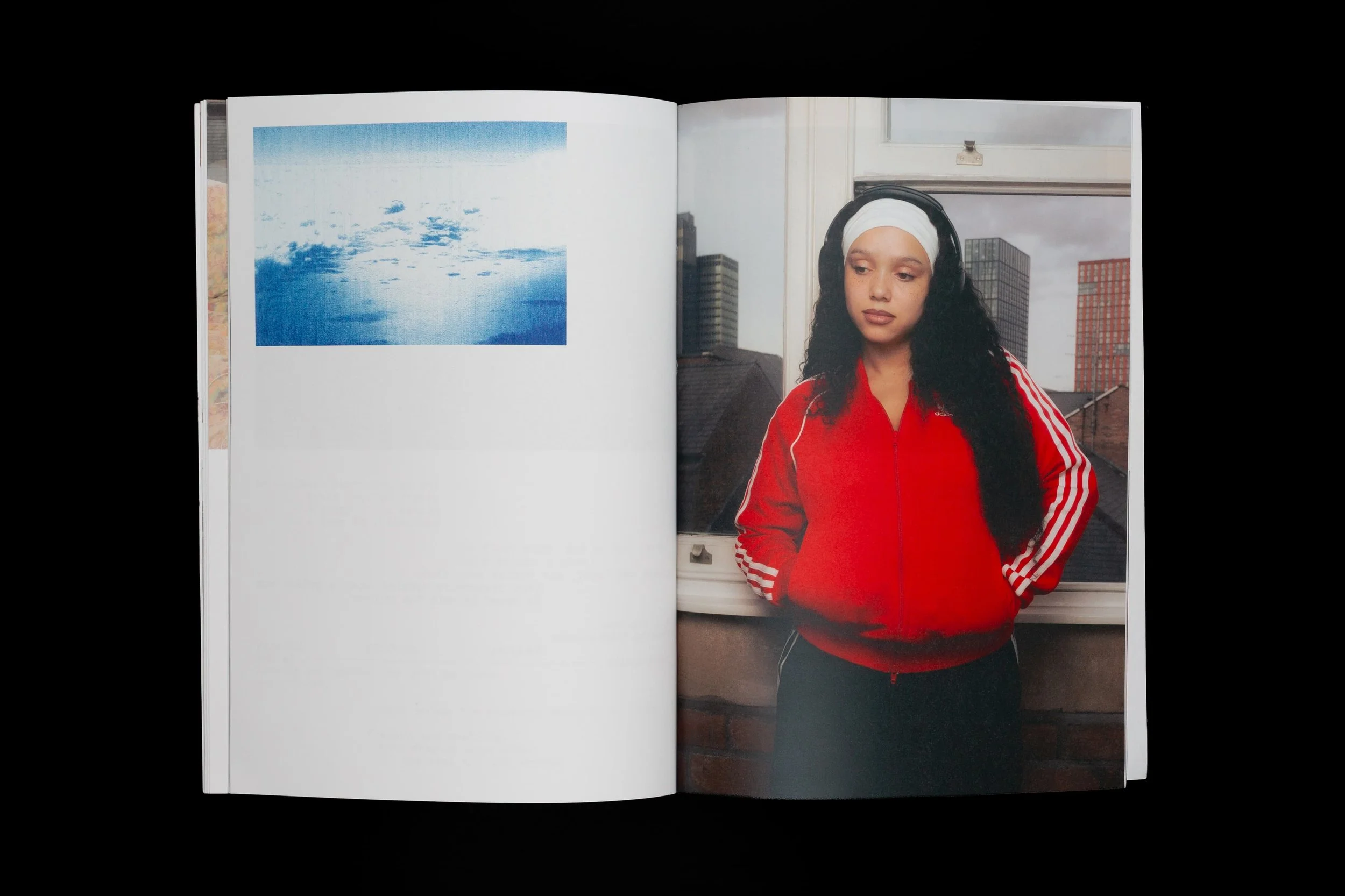 Colour portrait of a woman wearing a red adidas jacket and headphones overlooking Manchester, featured in the Common Frequency zine by Yaroslav Prytula.