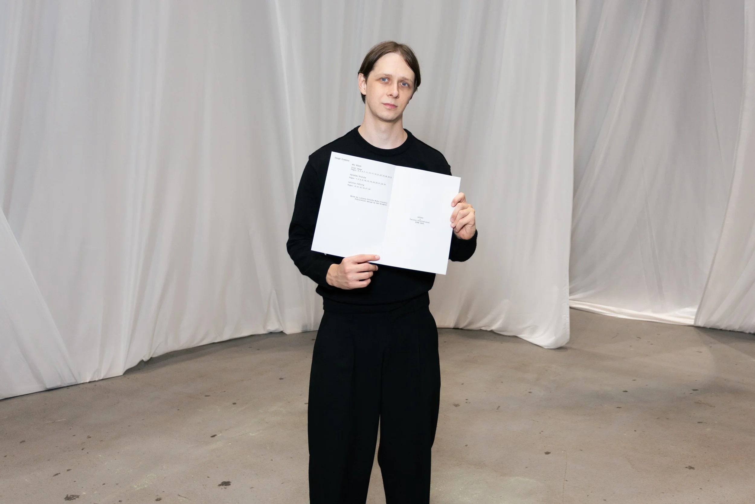 Manchester-based photographer and creative director Yaroslav Prytula holding the Common Frequency zine open to its credits page, created for adidas Originals Creator Network North.