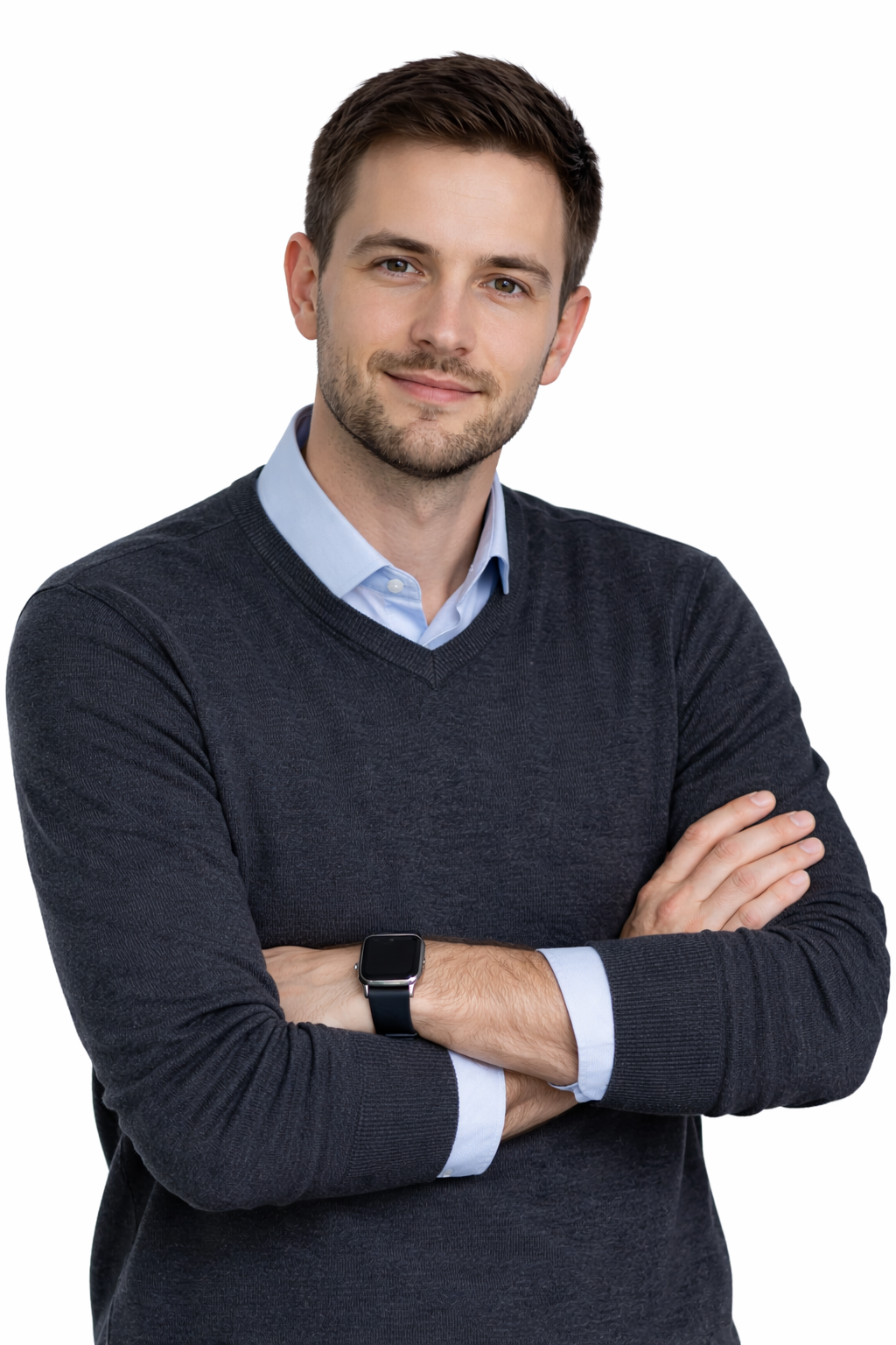 A young man with short brown hair and a beard, wearing a dark sweater over a light blue collared shirt, standing with arms crossed and smiling at the camera against a white background.