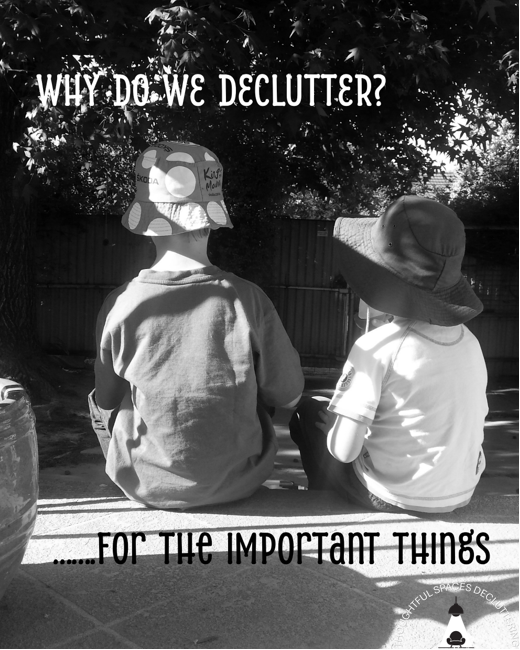Two children sitting on a ledge outdoors, wearing hats, with a wooden fence and trees in the background. Overlay text reads 'Why do we declutter? For the important things,' with the Thoughtful Spaces Decluttering watermark in the bottom right corner.