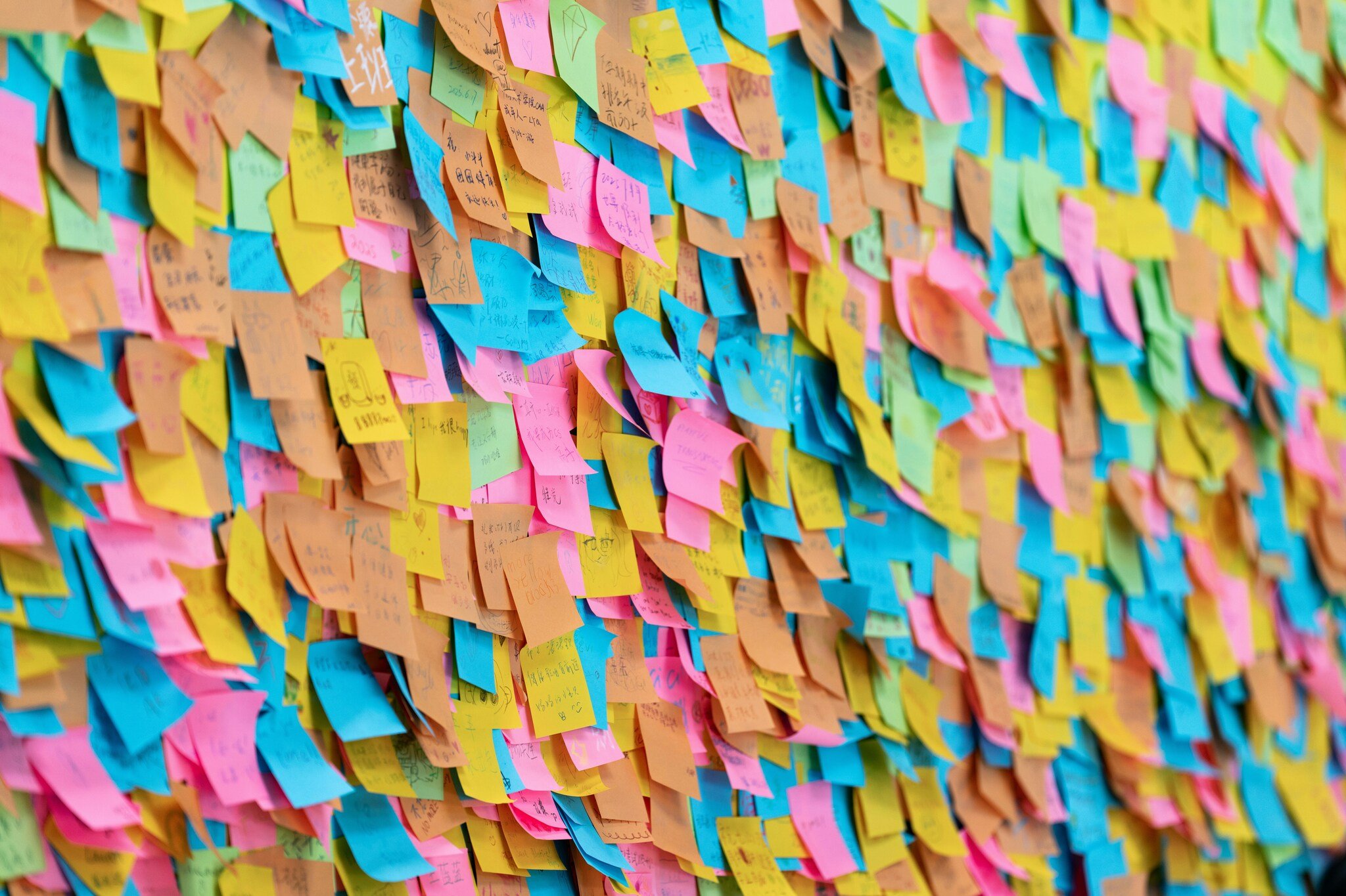 A wall full of sticky notes of different colours