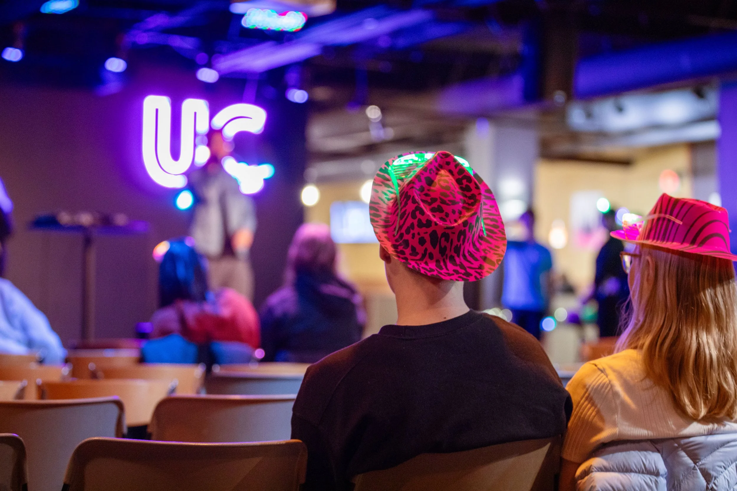 In UWW's University Center's Down Under, a couple watches a UCLive sponsored comedian, 2024.