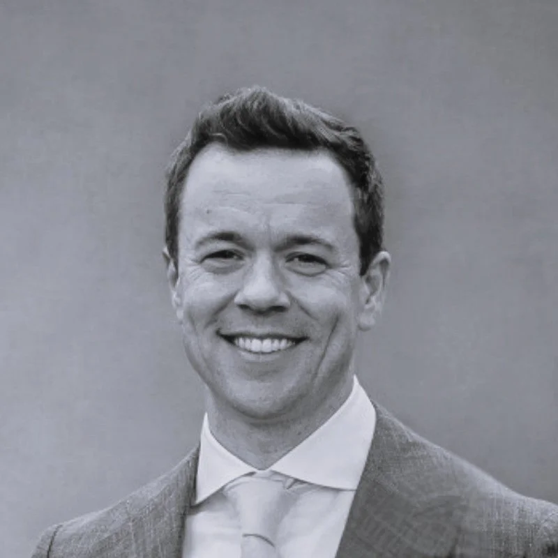 Person with long curly hair sitting in front of a whiteboard with notes and diagrams.