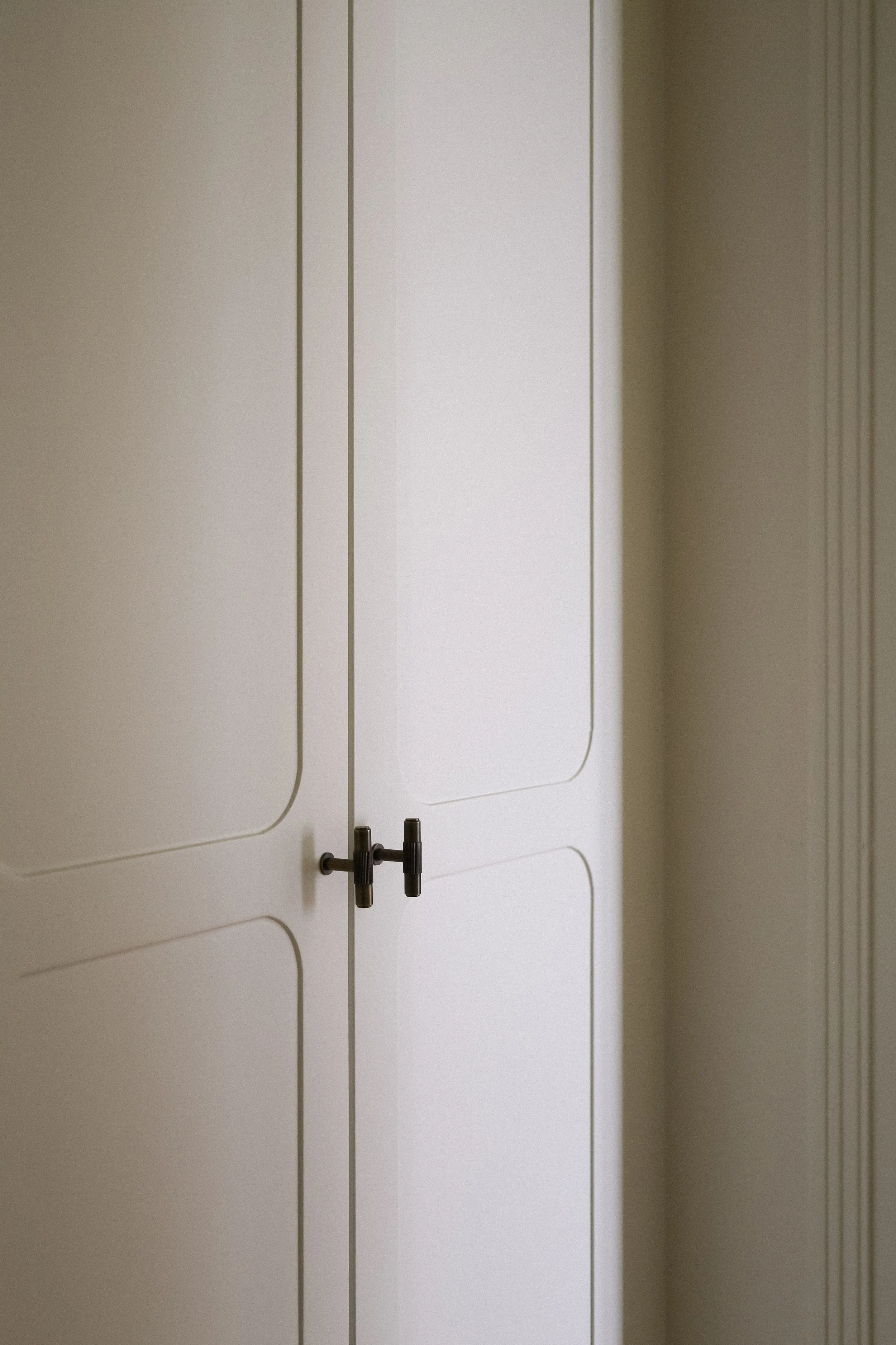 Armoire blanche avec deux portes et poignées noires