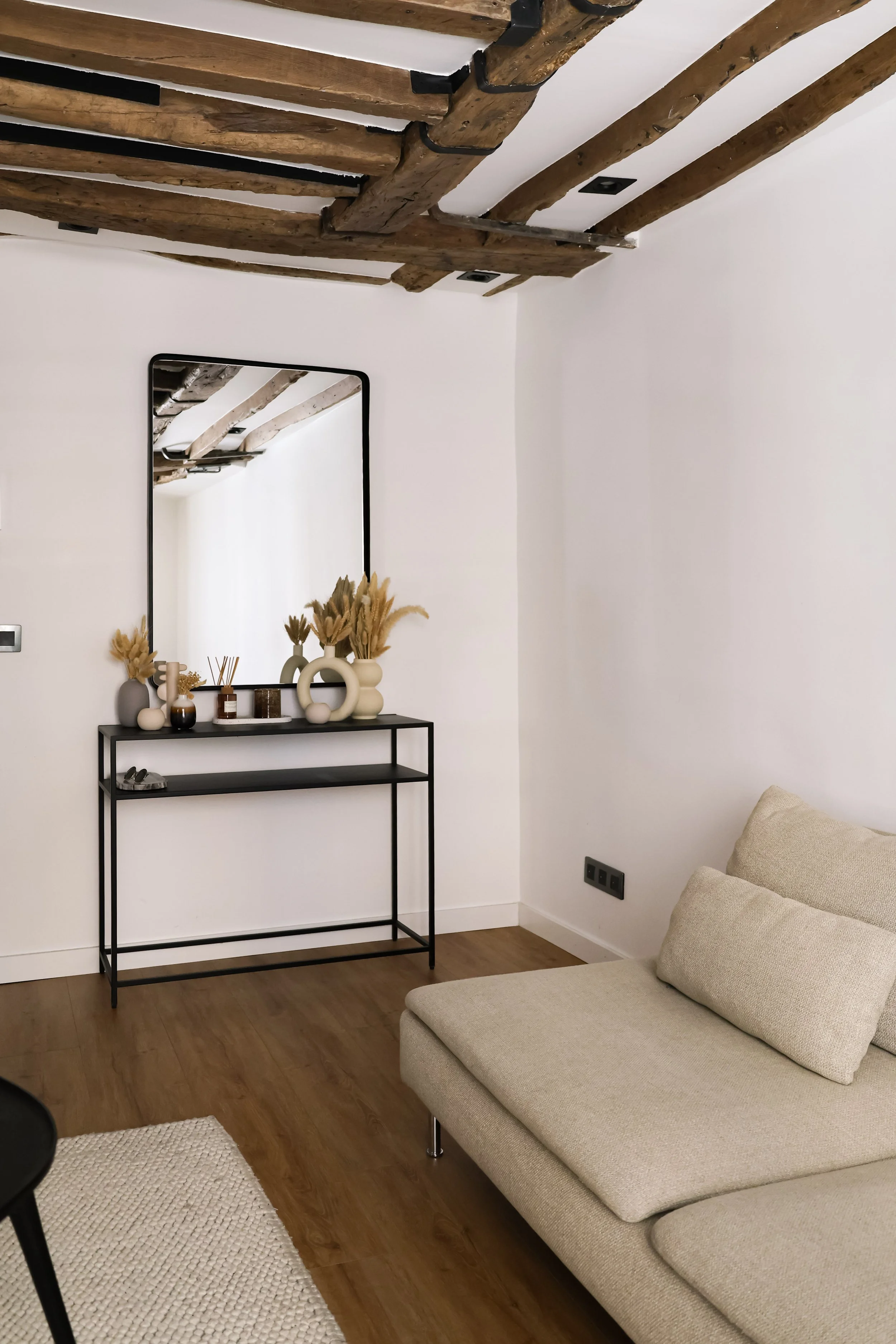 Architecture d’intérieur contemporaine minimaliste france : design sur mesure, décoration haut de gamme, gestion de chantier, conception. Salon intérieur avec plafond en poutres en bois, miroir accroché au mur