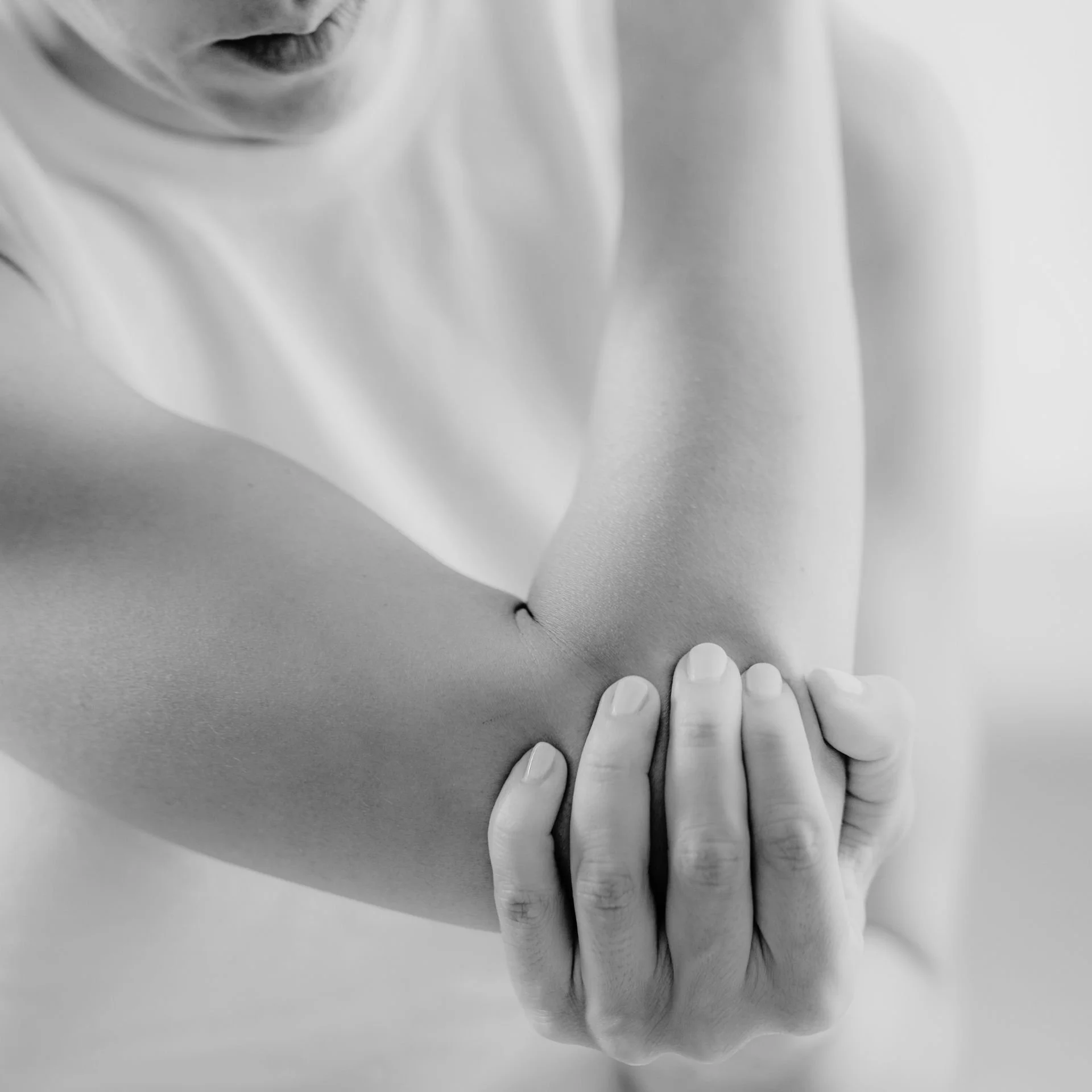 Homme tenant son coude douloureux – douleur articulaire du coude, possible épicondylite ou tendinite traitée par un chirurgien du coude à Nîmes.