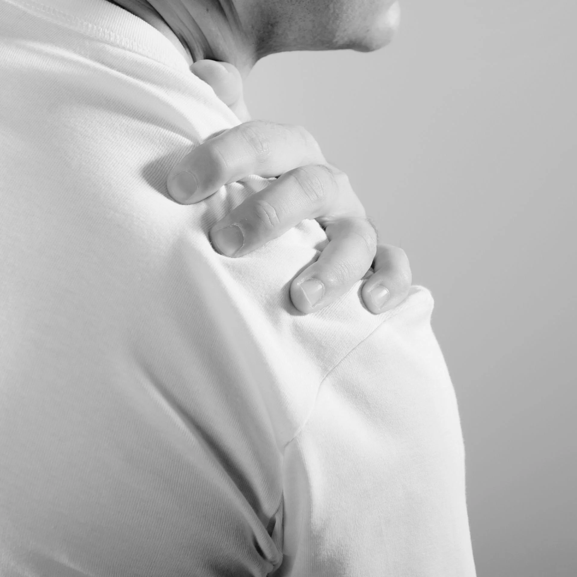 Homme tenant son épaule douloureuse – pathologie de la coiffe des rotateurs ou arthrose de l’épaule traitée par chirurgie à Nîmes.