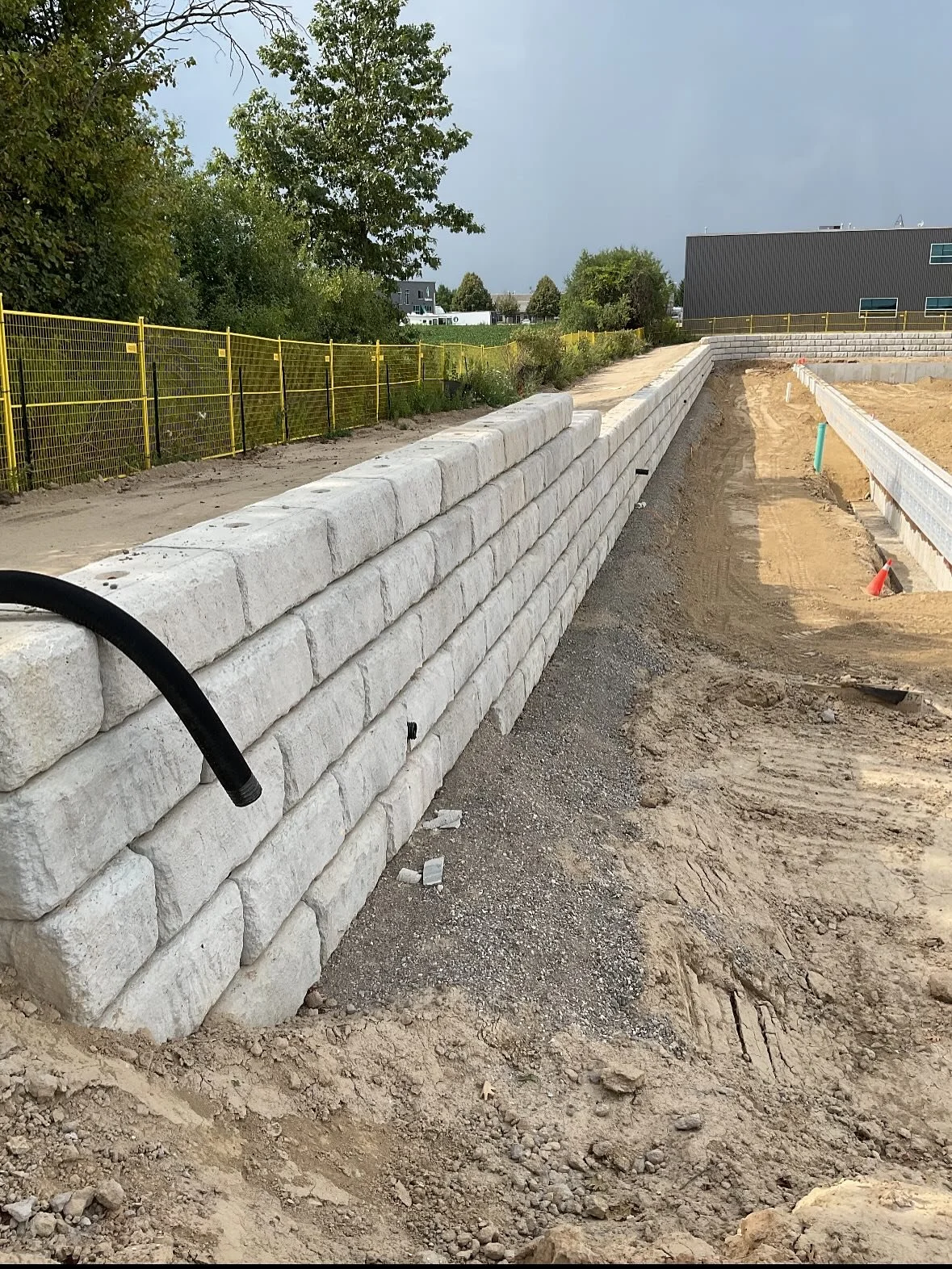 Retaining walls aren&rsquo;t something we build all the time &mdash; but when a trusted client calls, we make it happen.
950 feet of two-stage Redi-Rock wall, delivered ahead of schedule. Solid work by the crew on this one &mdash; great execution fro