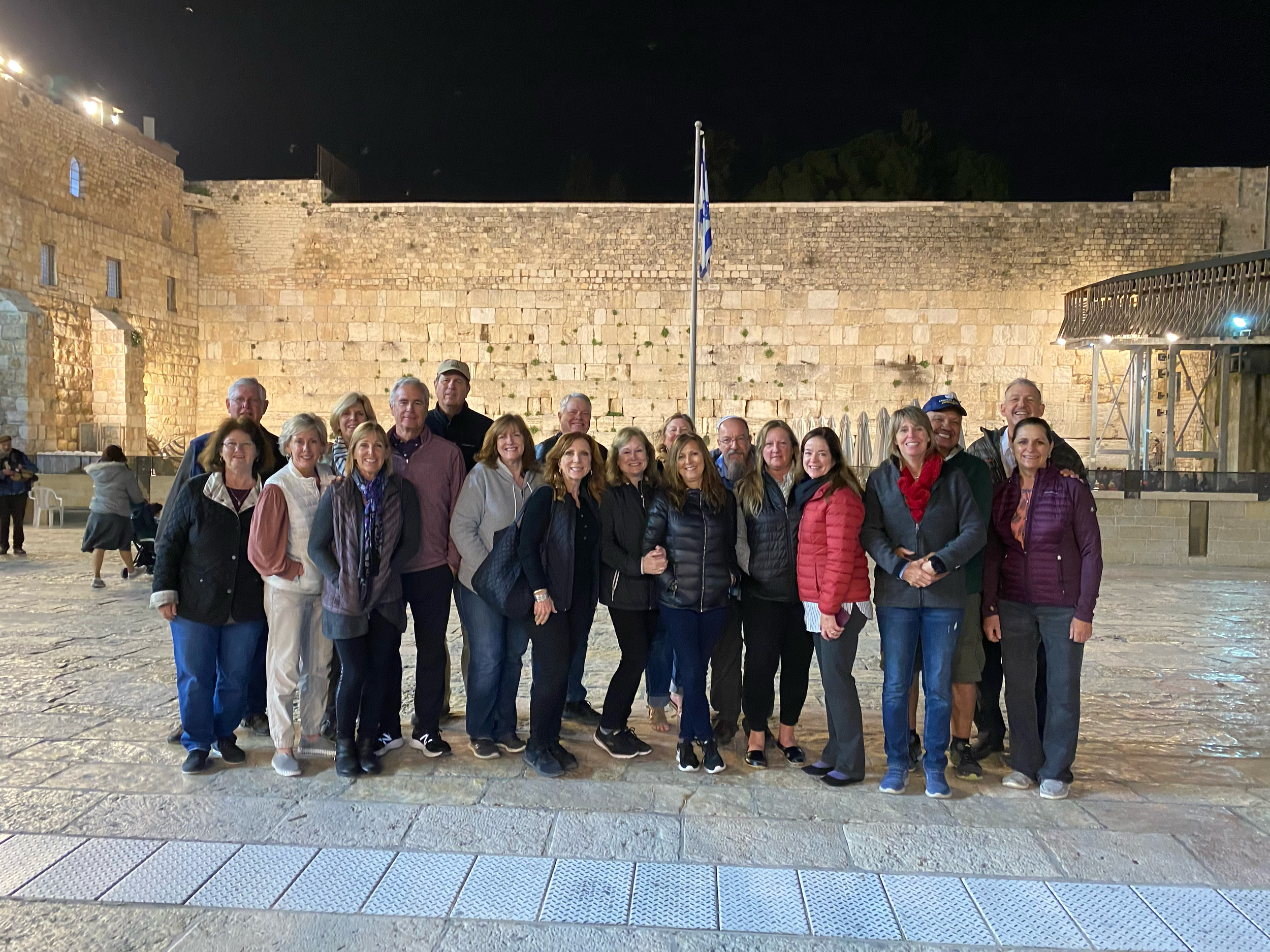 Group of people posing in front of the Western Wall at night