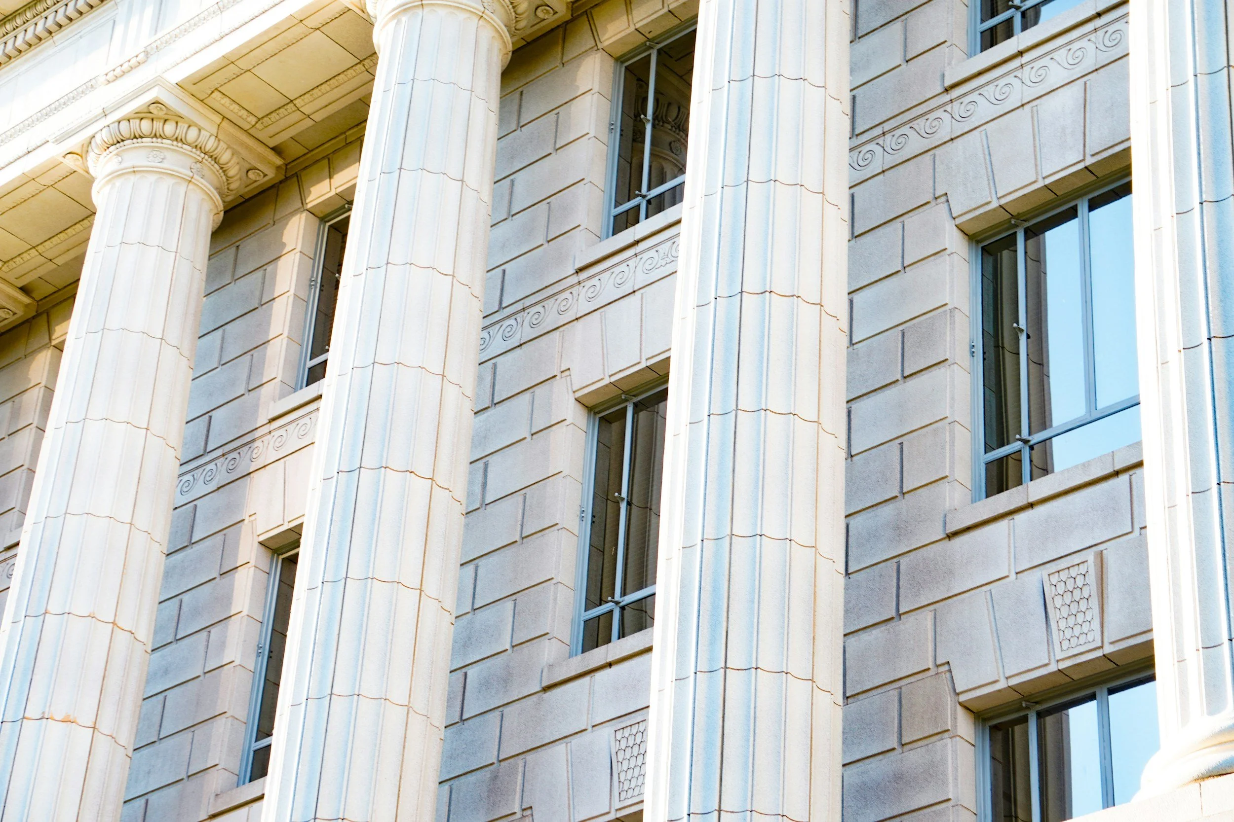 Close-up of a classical-style building facade with large columns and rectangular windows.