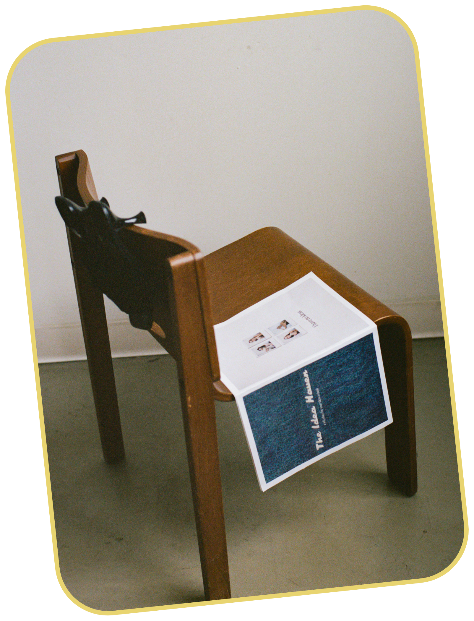 Wooden chair with a mock newspaper for The Idea Haven draped over the seat. The newspaper has dark blue denim image with the words "The Idea Haven" features four small images of Taylor on back cover.