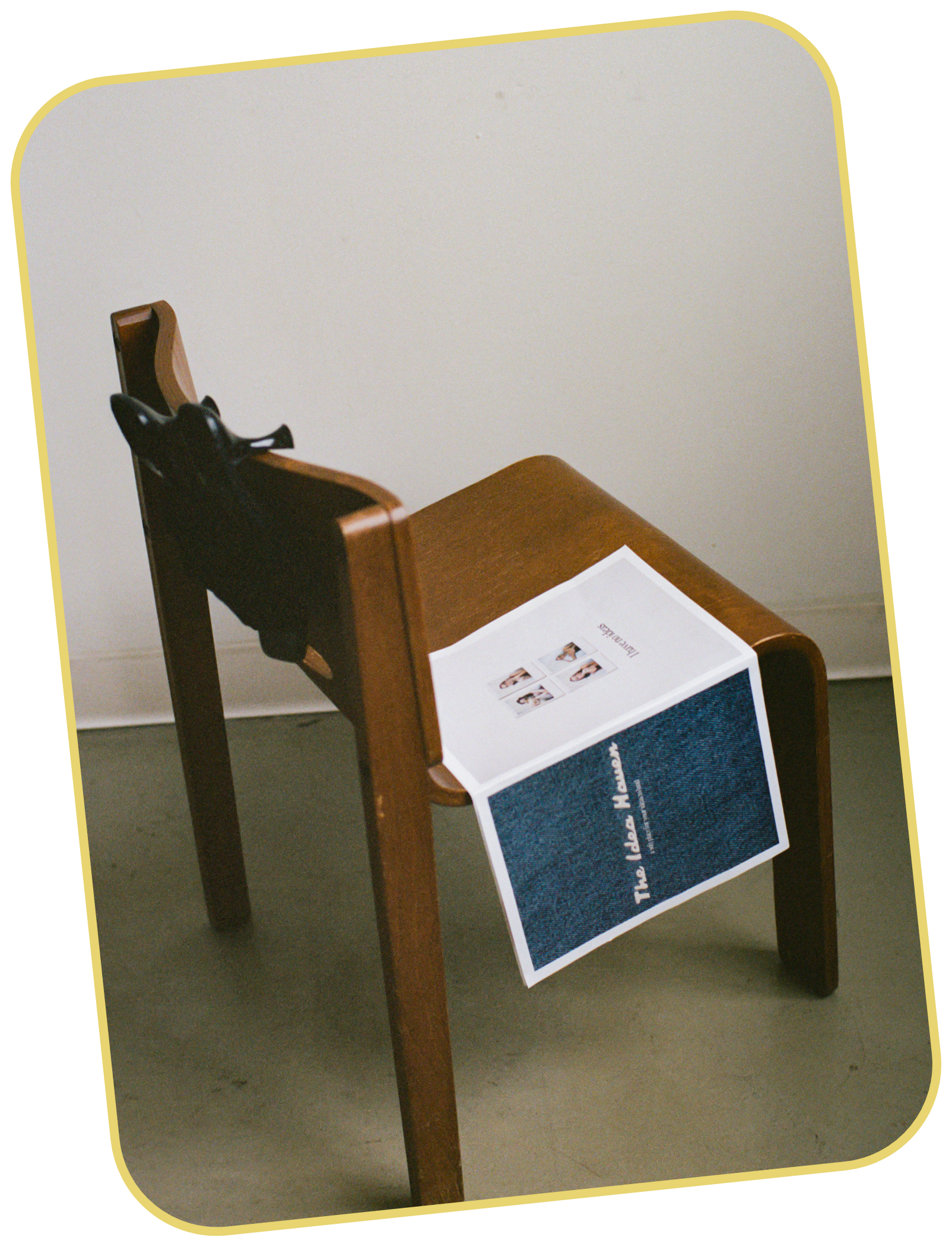 Wooden chair with a mock newspaper for The Idea Haven draped over the seat. The newspaper has dark blue denim image with the words "The Idea Haven" features four small images of Taylor on back cover.
