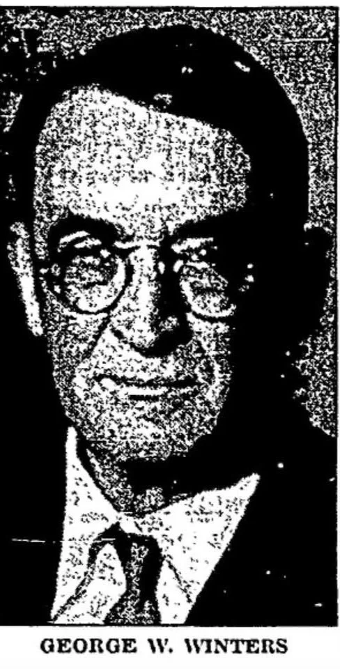 Black and white high-contrast portrait of George W. Winters wearing glasses and a suit with a tie.