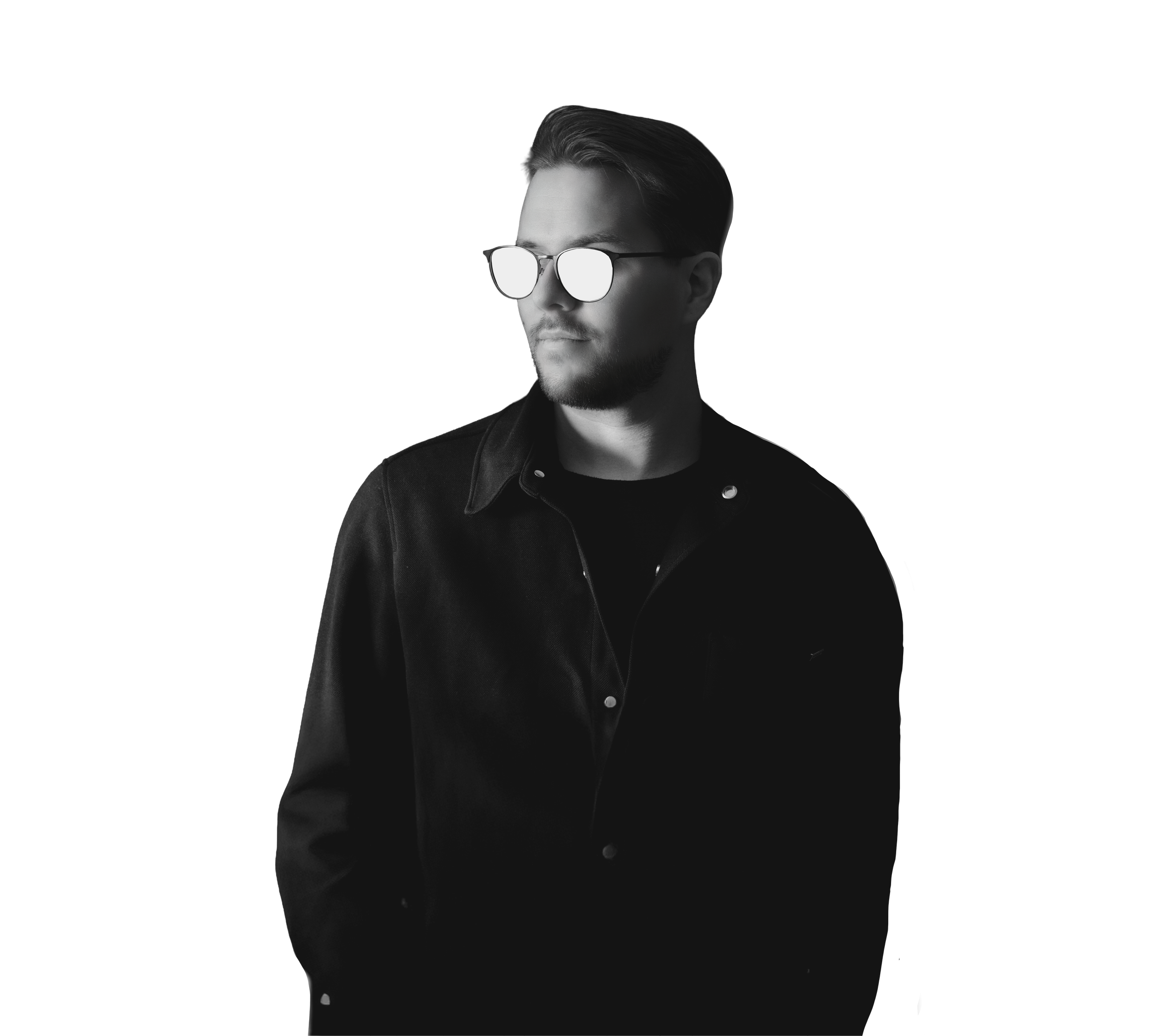 Black-and-white photo of a man with short hair, beard, and sunglasses, wearing a black jacket, looking to the side against a dark background.