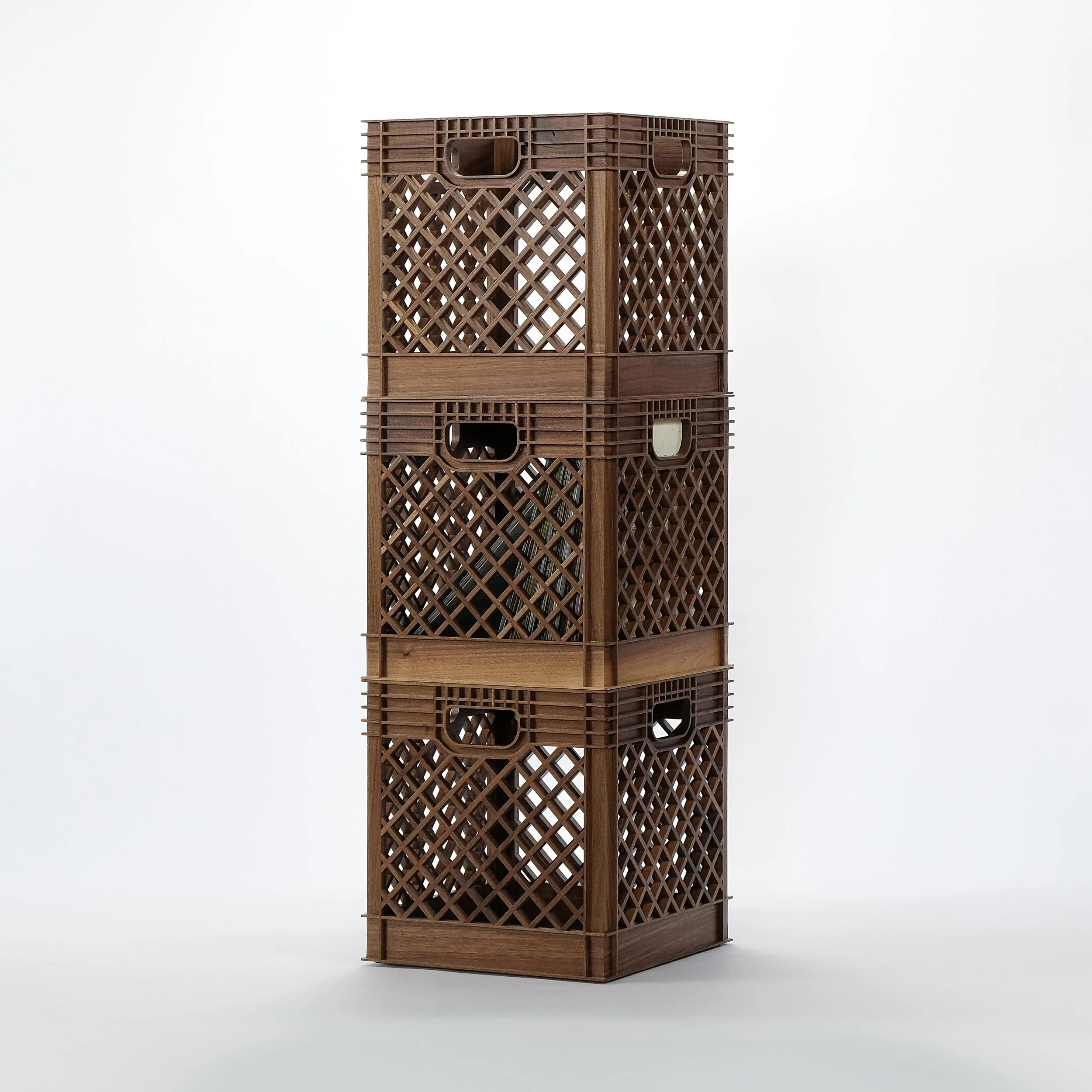 Stack of four brown plastic crates with lattice sides and handle openings, against a plain white background.