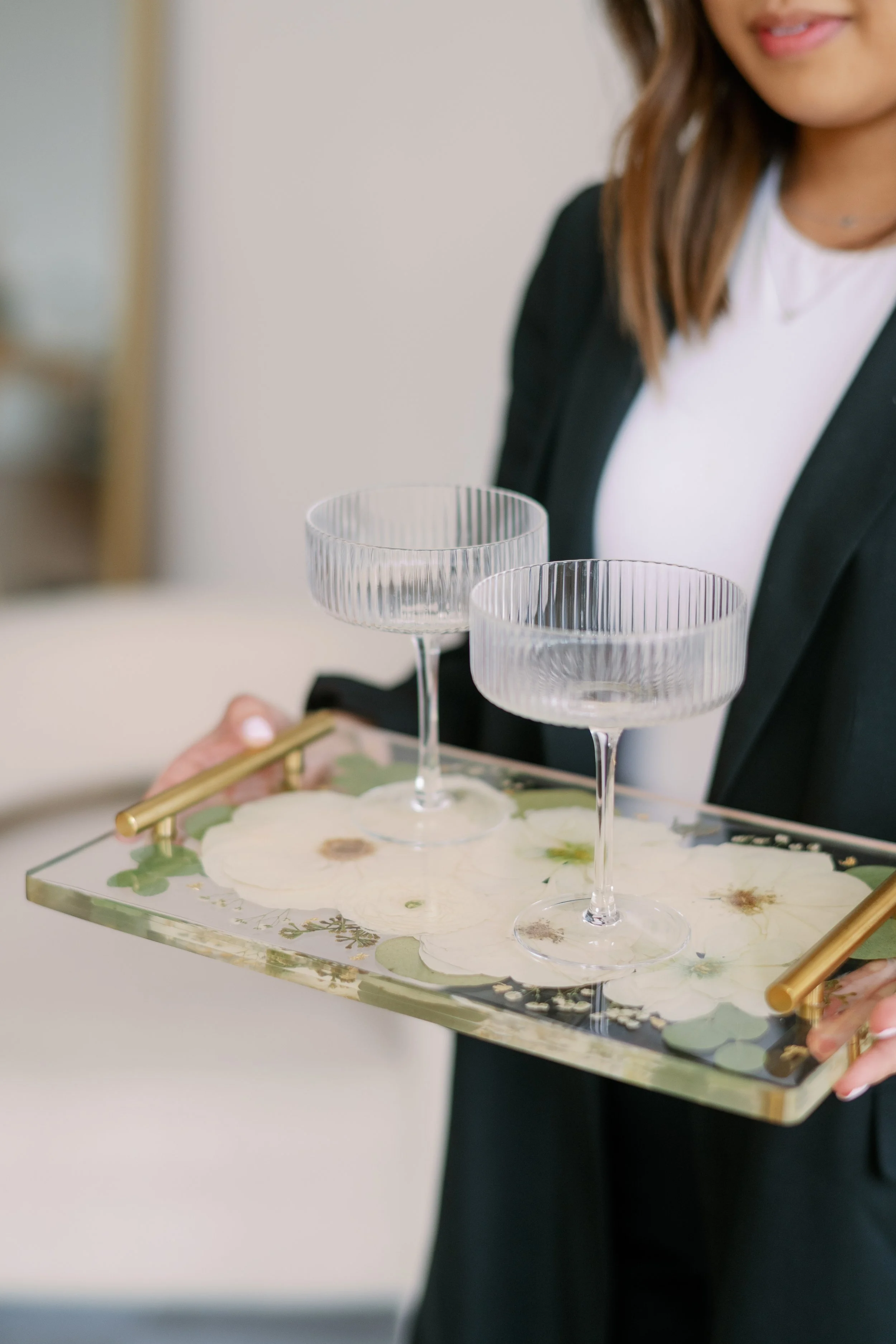 Vivian, owner of Vivian x Co, holding up a resin floral tray with gold handles