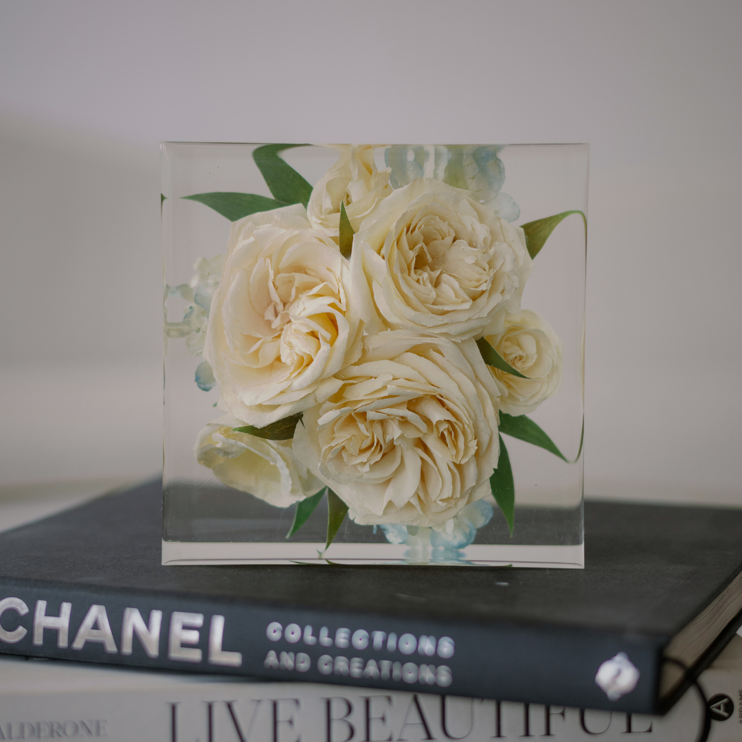 6-inch resin square preserving ivory roses and greenery displayed on a stack of fashion books