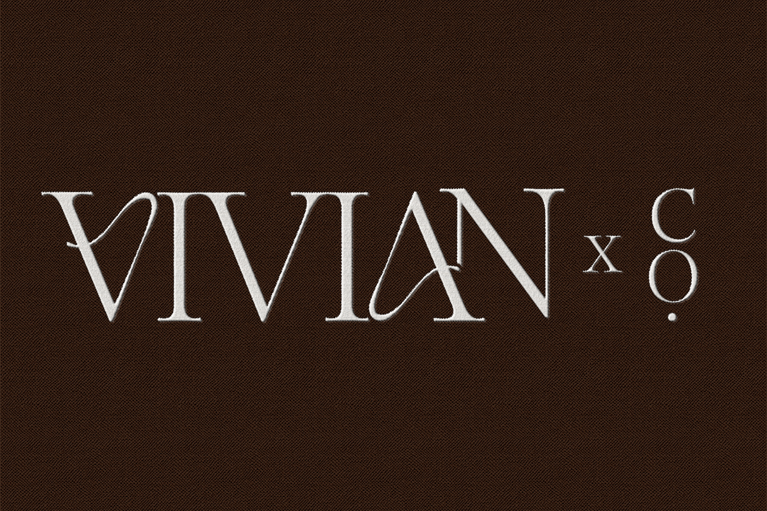 White embroidered lettering on dark brown fabric
