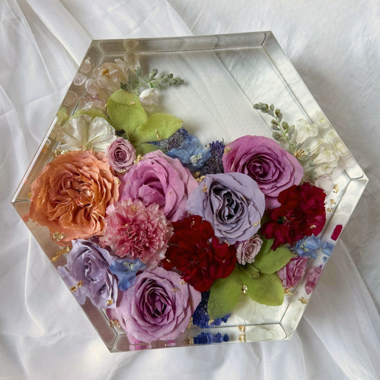 Clear 10-inch resin hexagon preserving orange, blush, lavender, and purple roses with red flowers and greenery