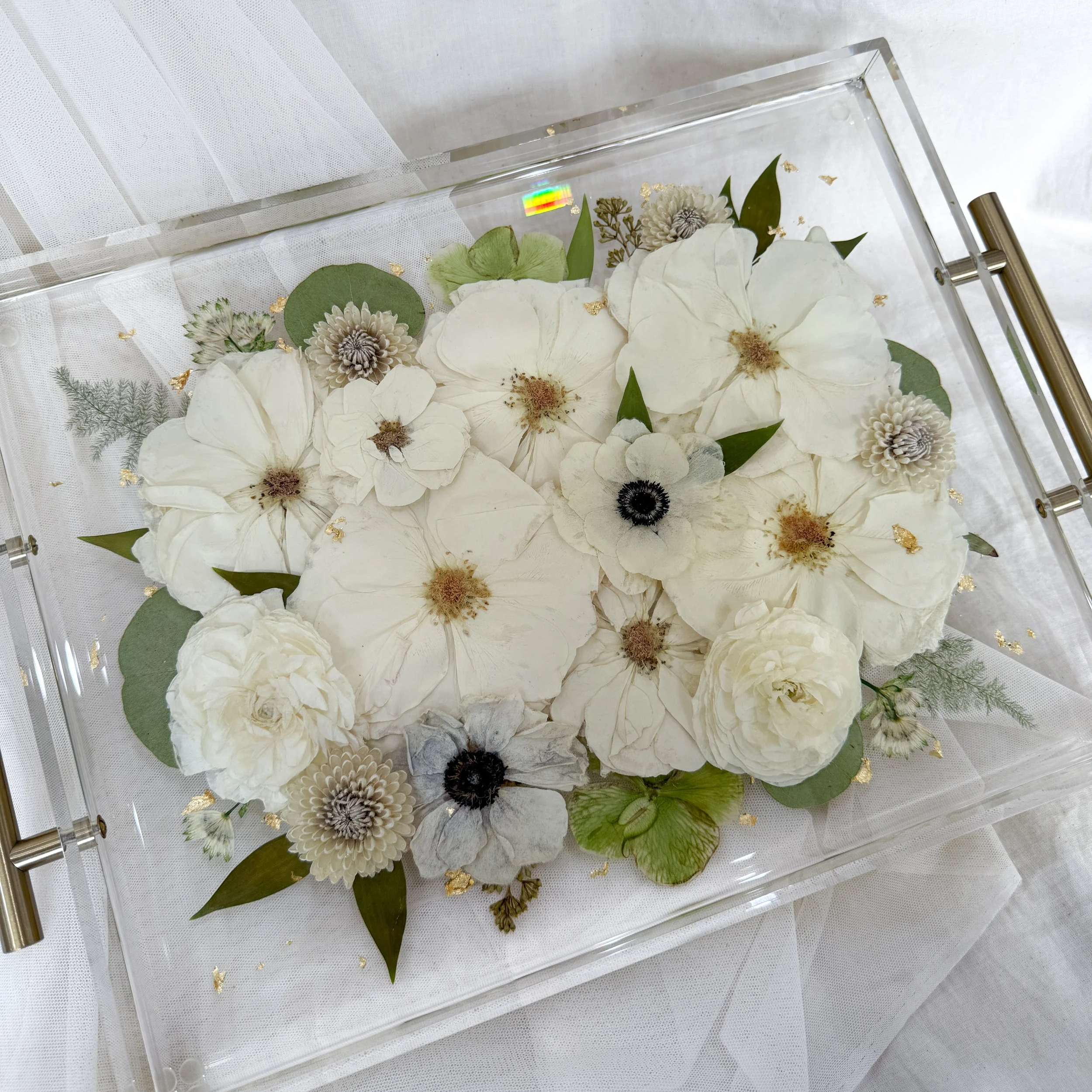 11-by-14-inch acrylic tray with silver handles preserving white roses, anemones, and other ivory flowers with greenery
