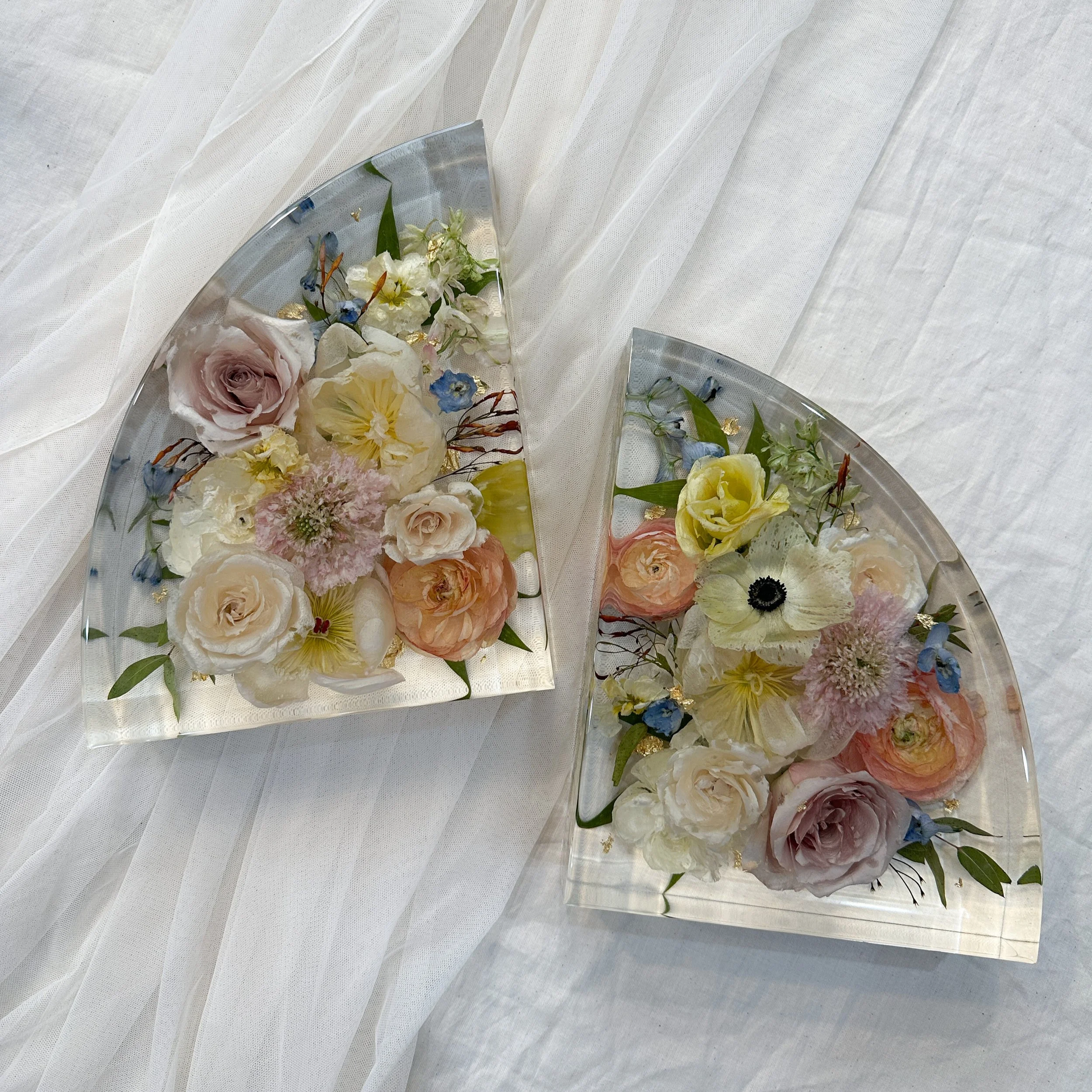 Pair of 9-inch resin bookends preserving blush, ivory, and orange roses with yellow flowers, blue hydrangea, and greenery