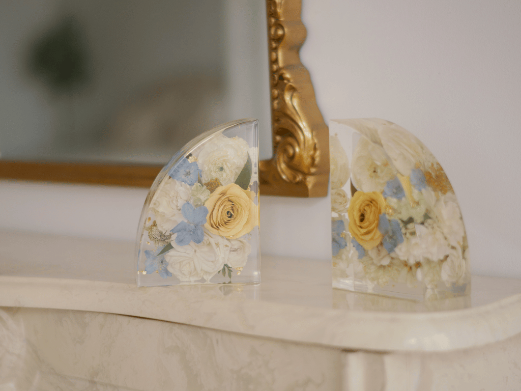 Resin flower preservation sculptures with embedded white, yellow, and blue flowers