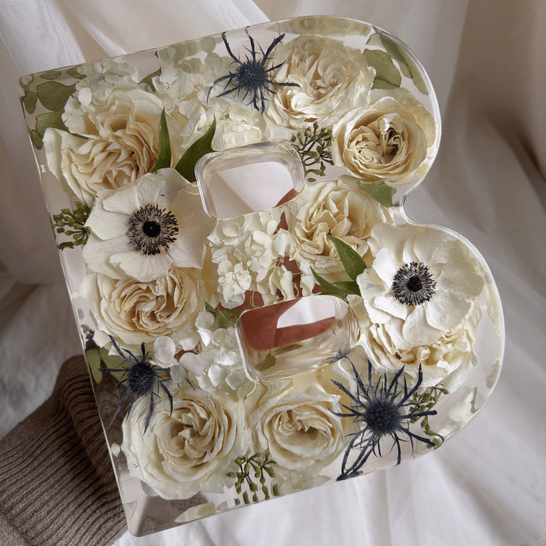 9-inch B-shaped resin letter block preserving ivory roses, white flowers, and delicate dark floral accents