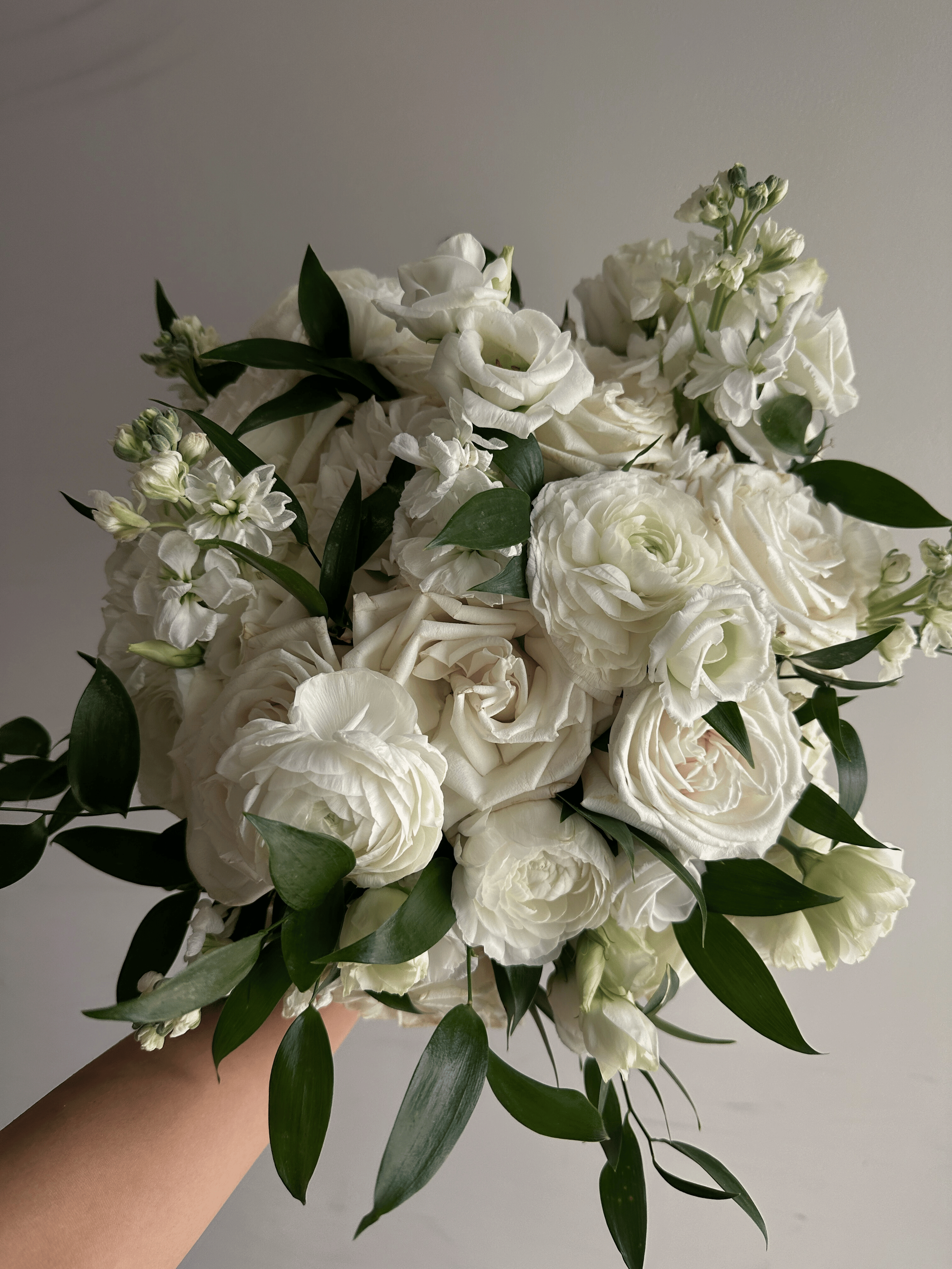 White flower bouquet with roses, lisianthus, and greenery