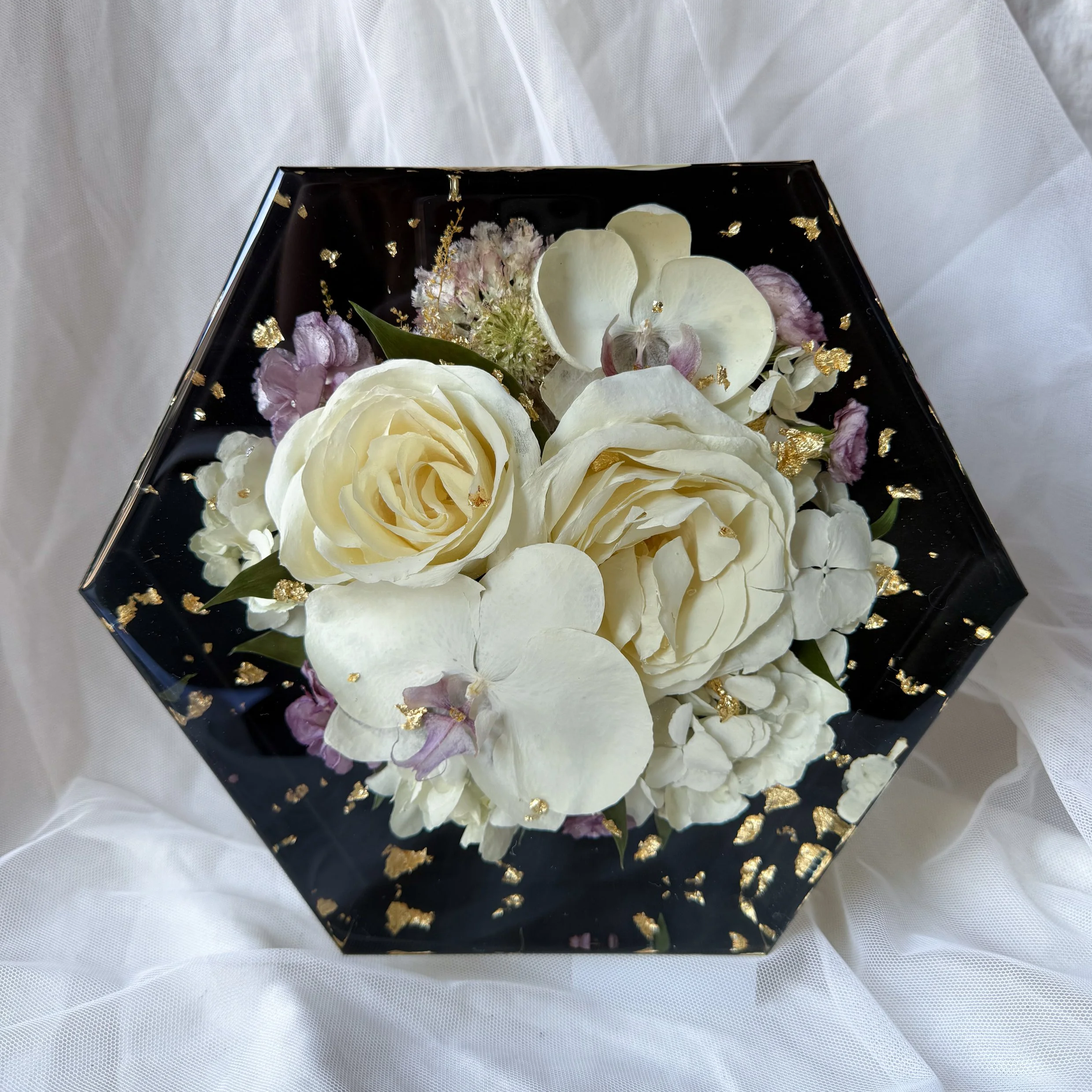 Black 8-inch resin hexagon featuring preserved white roses, orchids, and delicate floral accents