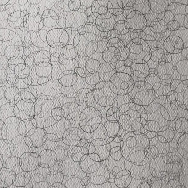 A surface covered with numerous small, overlapping black ink circles of various sizes.