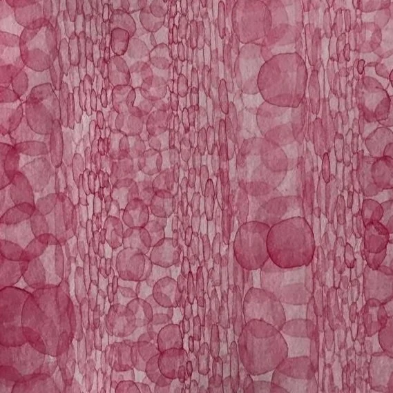 A close-up view of a textured pink and purple surface resembling a watercolor pattern or abstract art with various circular shapes.